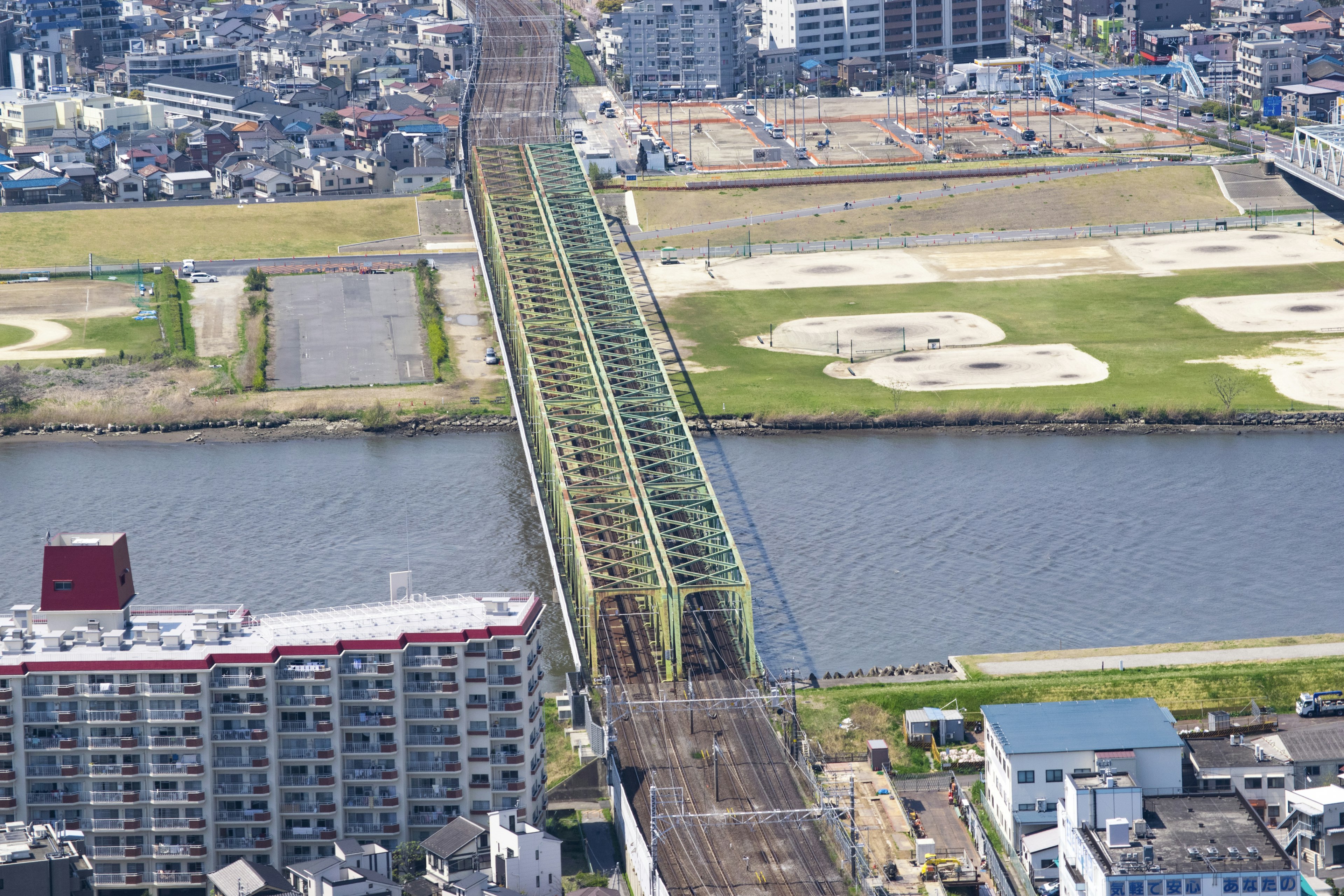 Luftaufnahme einer grünen Eisenbahnbrücke und der umliegenden Stadtlandschaft