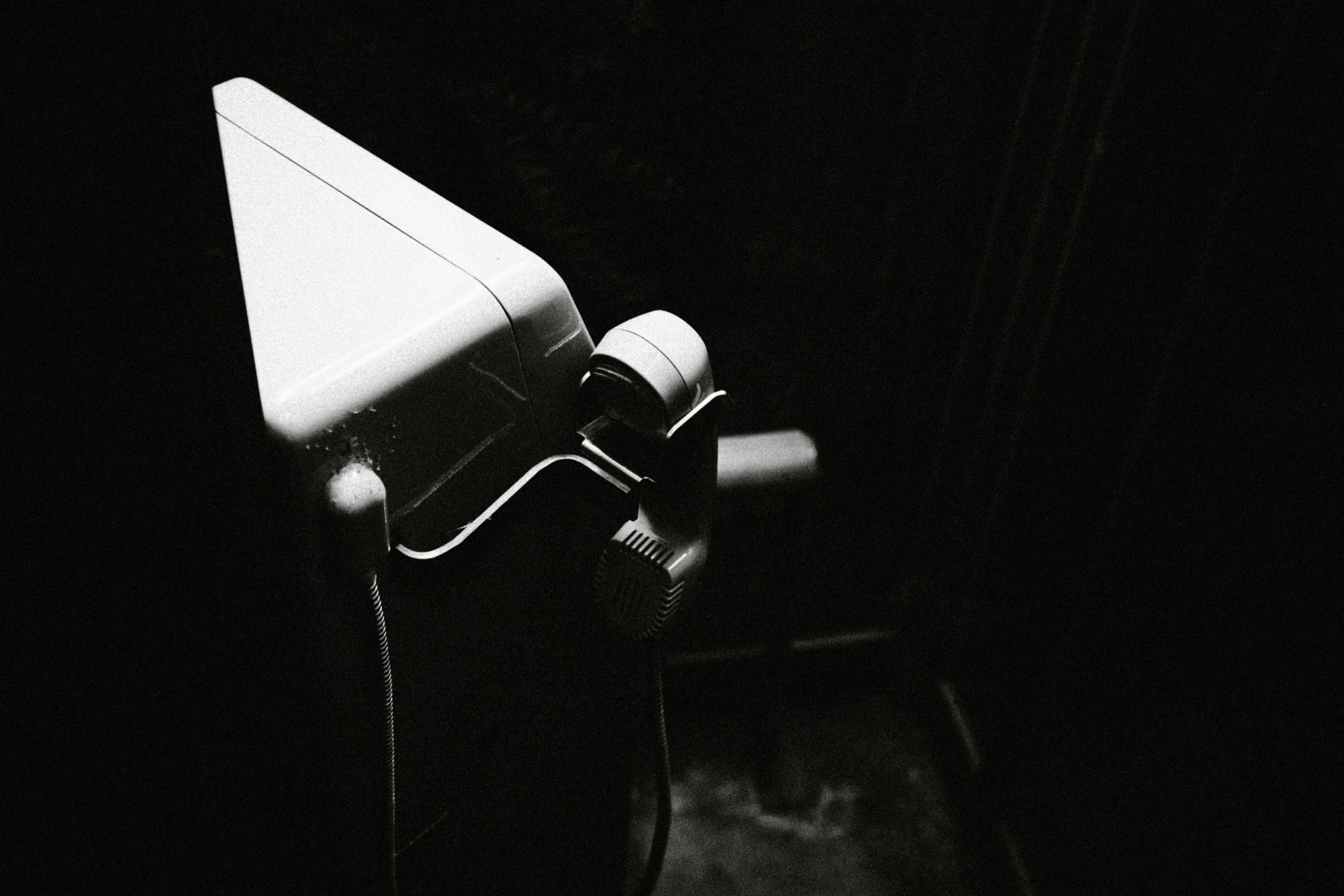 White toilet bowl corner illuminated against a dark background