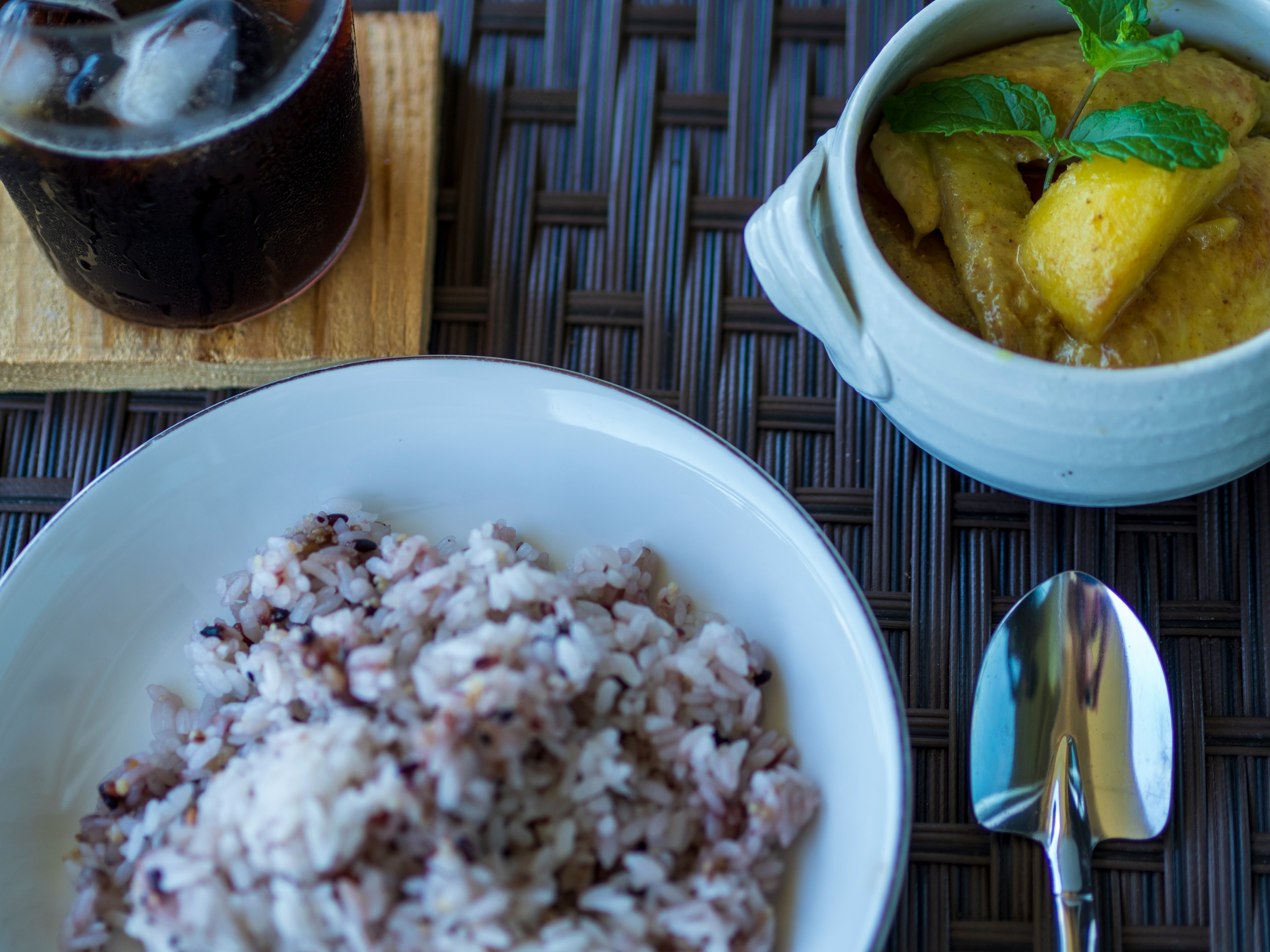 Un pasto con riso bianco e riso viola accompagnato da un piatto al curry