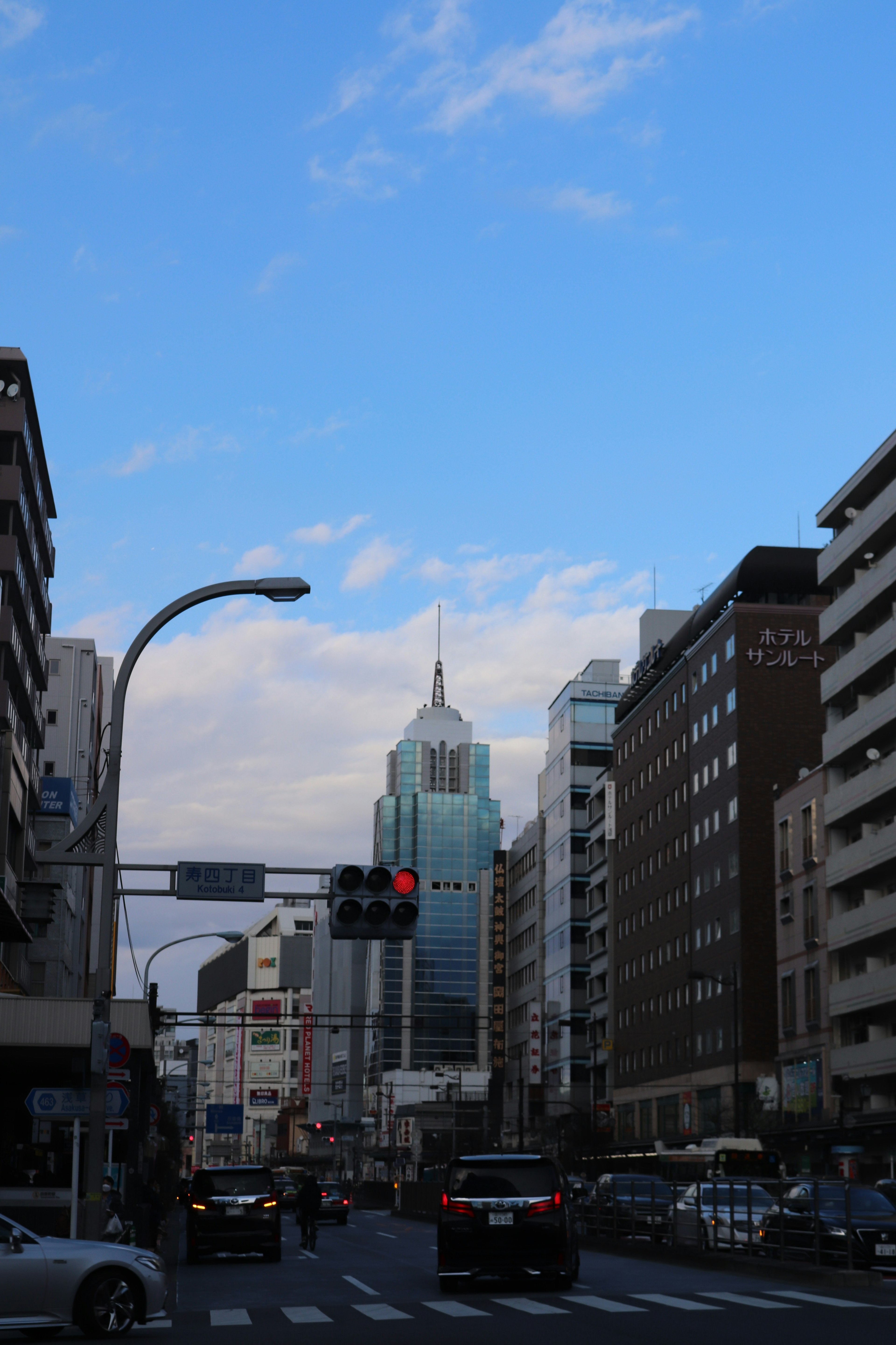 Paisaje urbano con rascacielos bajo un cielo azul y nubes