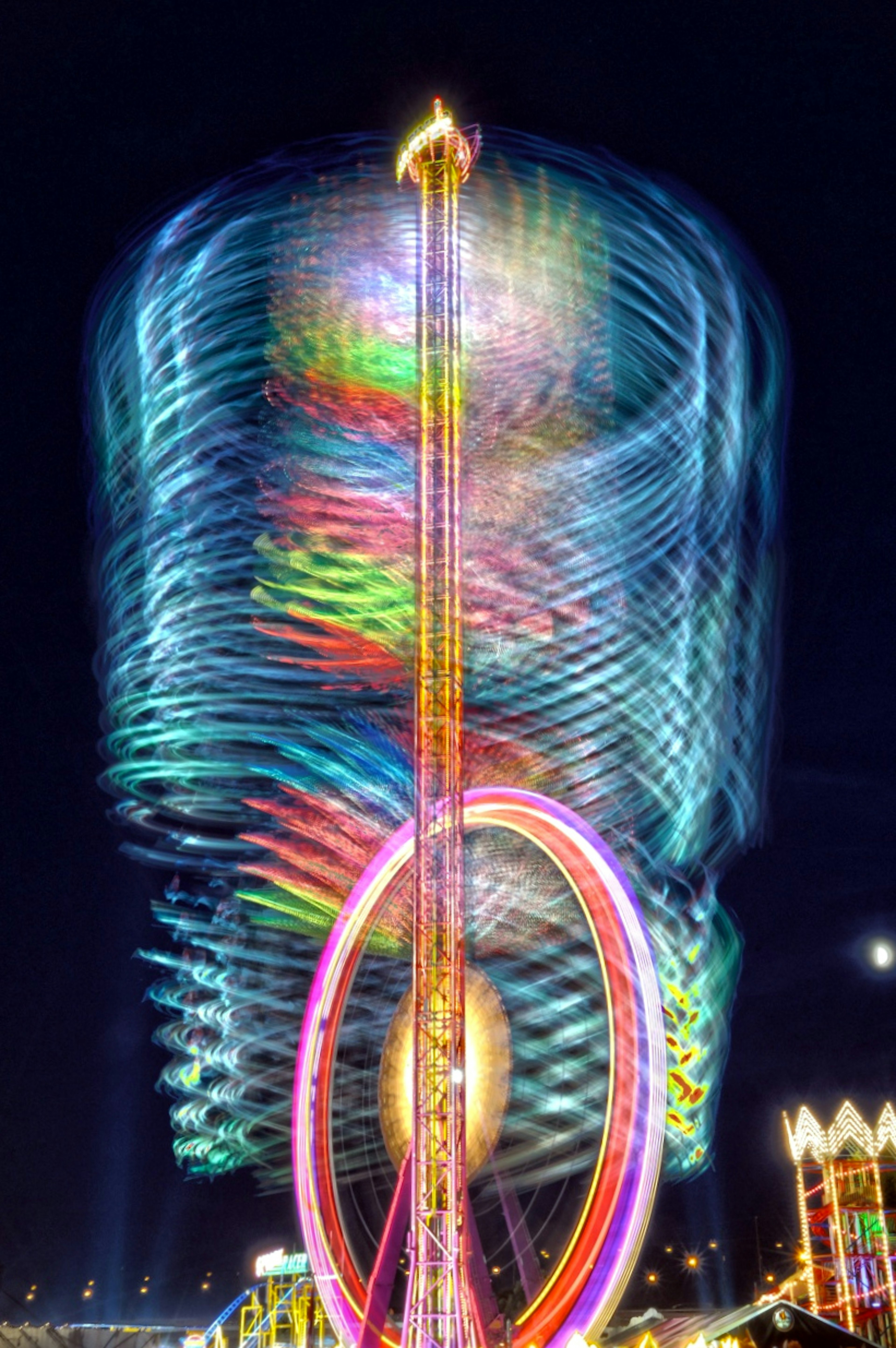 Colorful spinning Ferris wheel at night