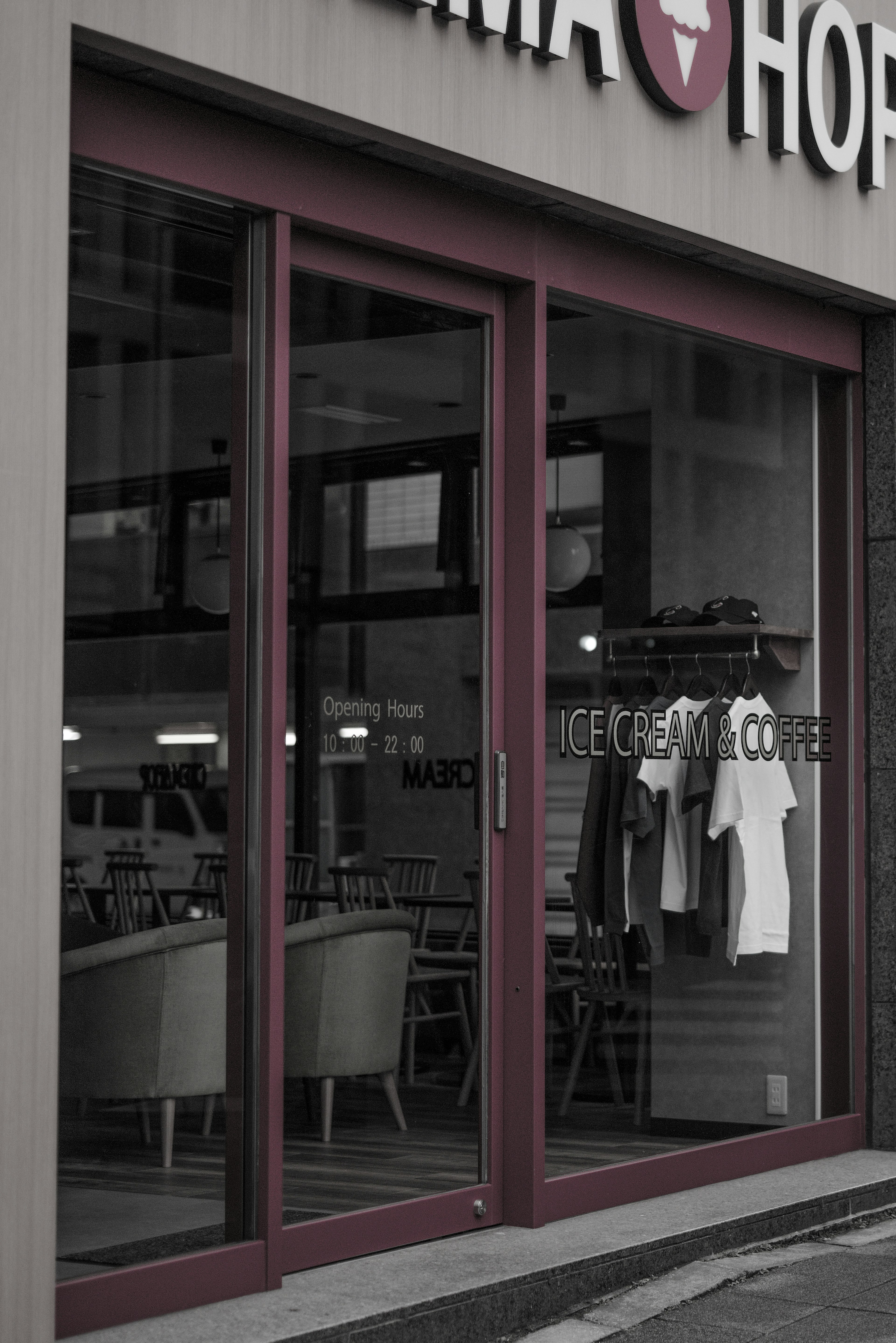 Image of an ice cream shop entrance showcasing interior seating and displayed clothing