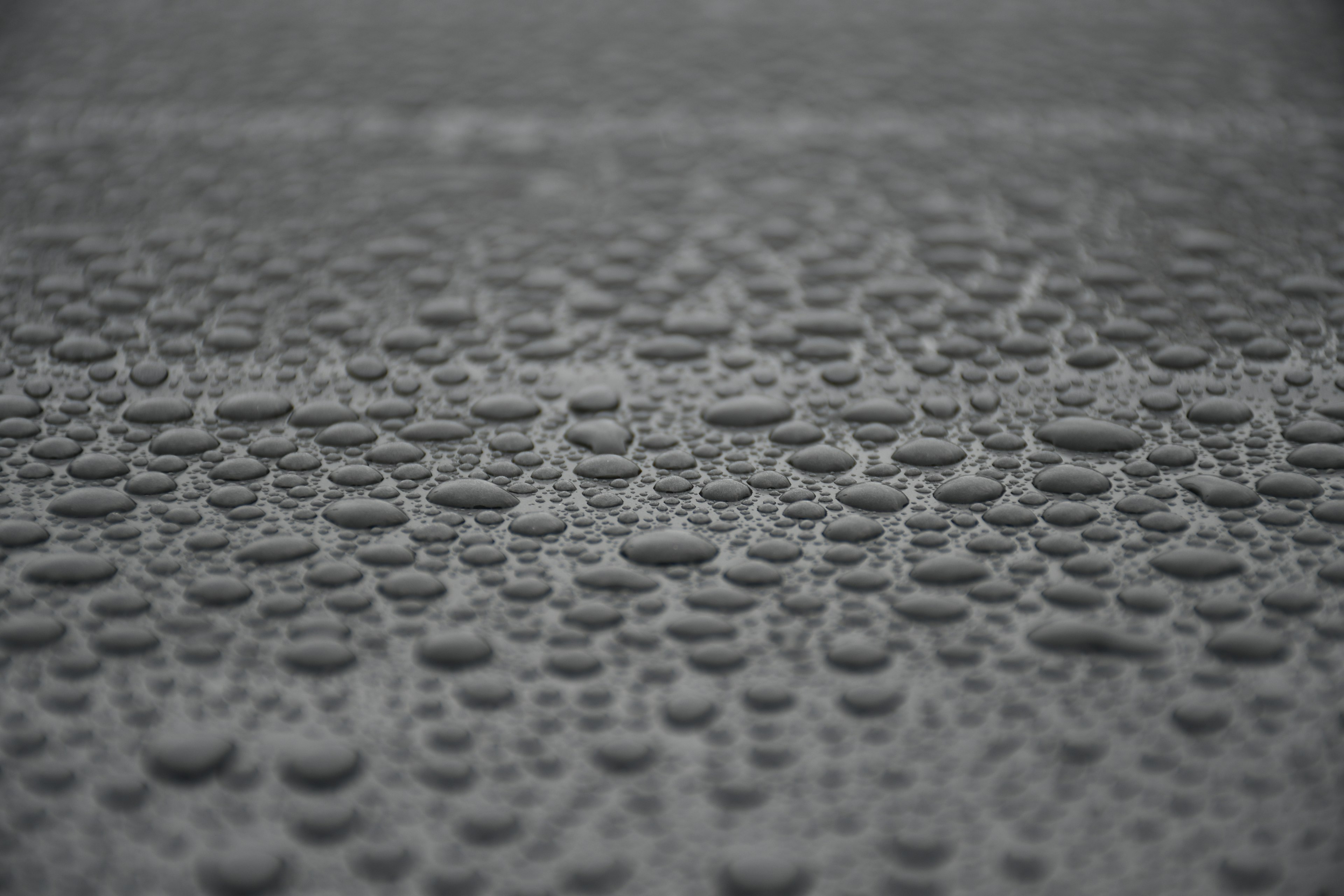 Close-up of water droplets on a dark gray surface