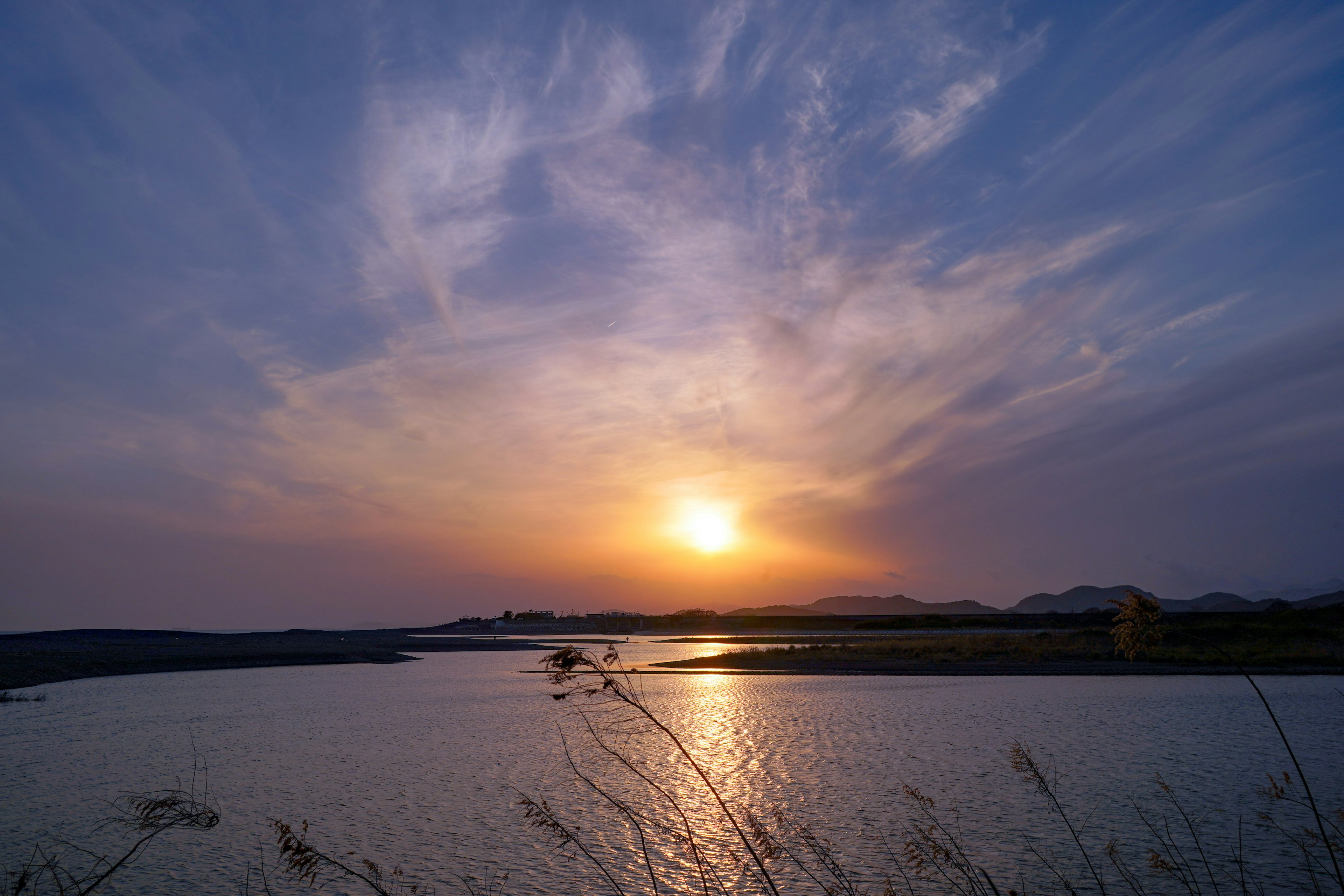 夕日が沈む川の風景と青い空