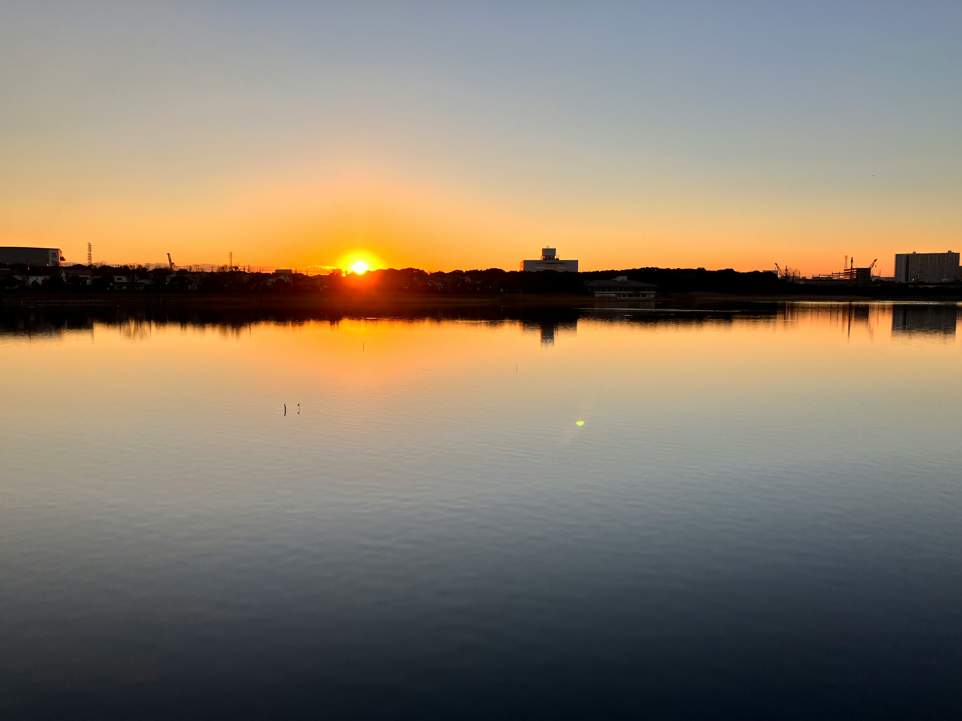 静かな湖に映る美しい夕日と穏やかな空の色合い