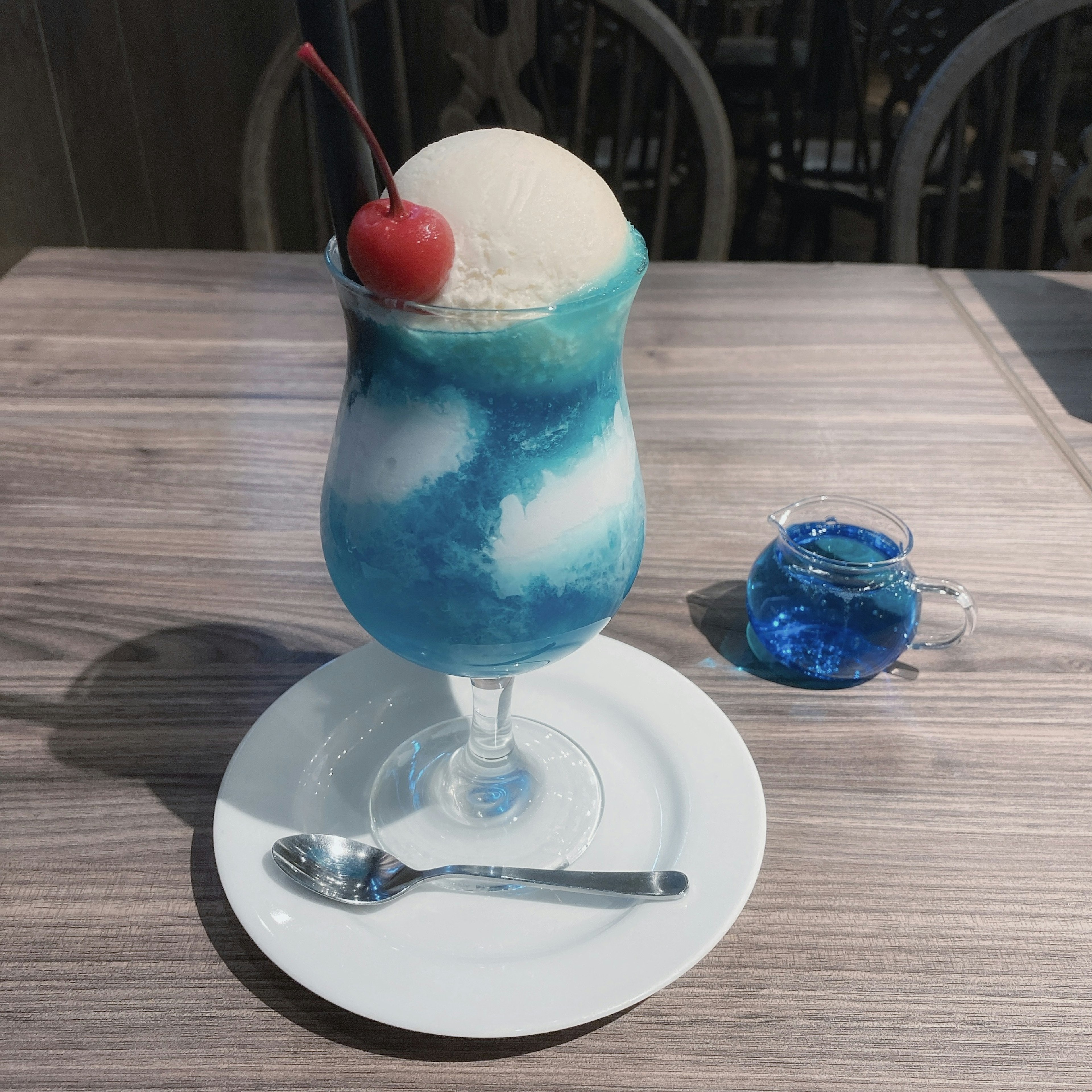 Postre de bebida azul con helado coronado con una cereza