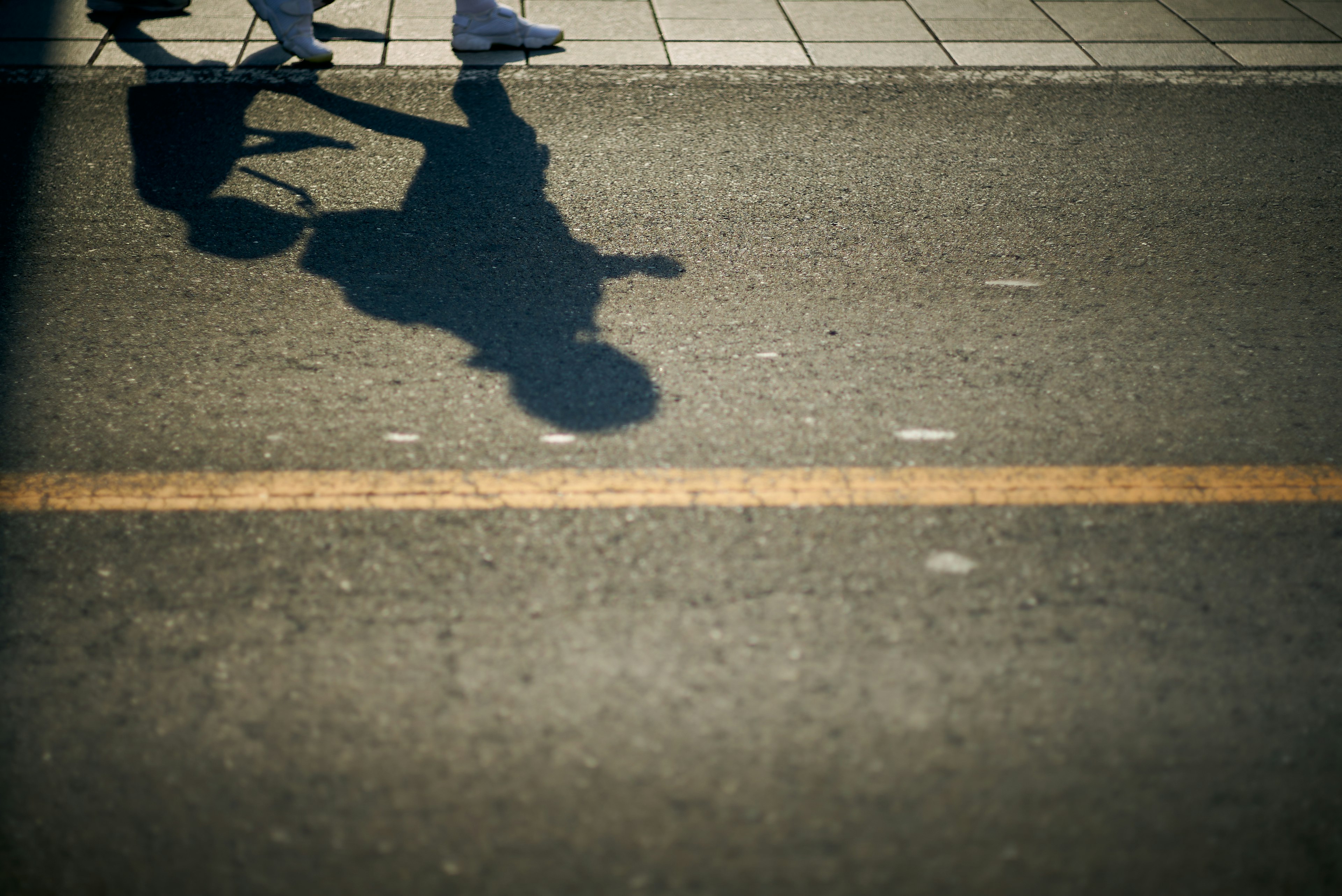 道路の影を持つ歩行者のシルエット