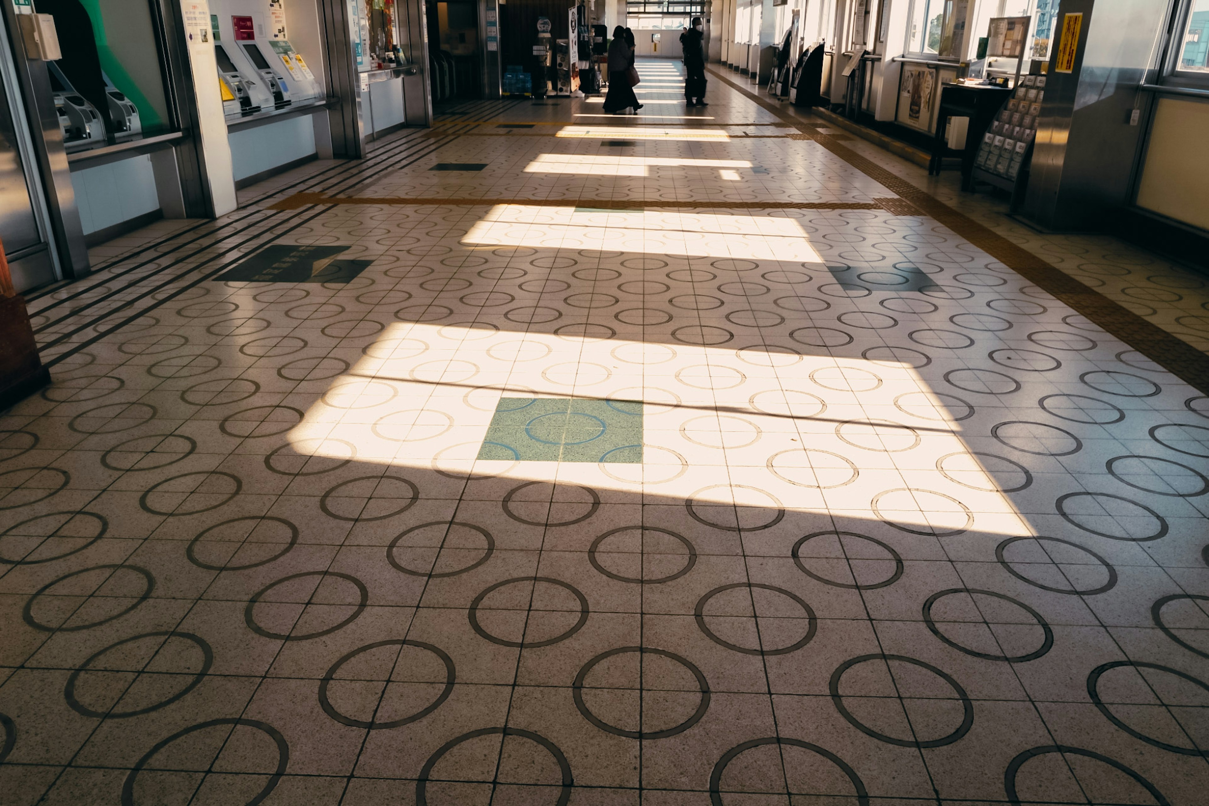 Sol avec des carreaux circulaires et de la lumière du soleil dans une gare