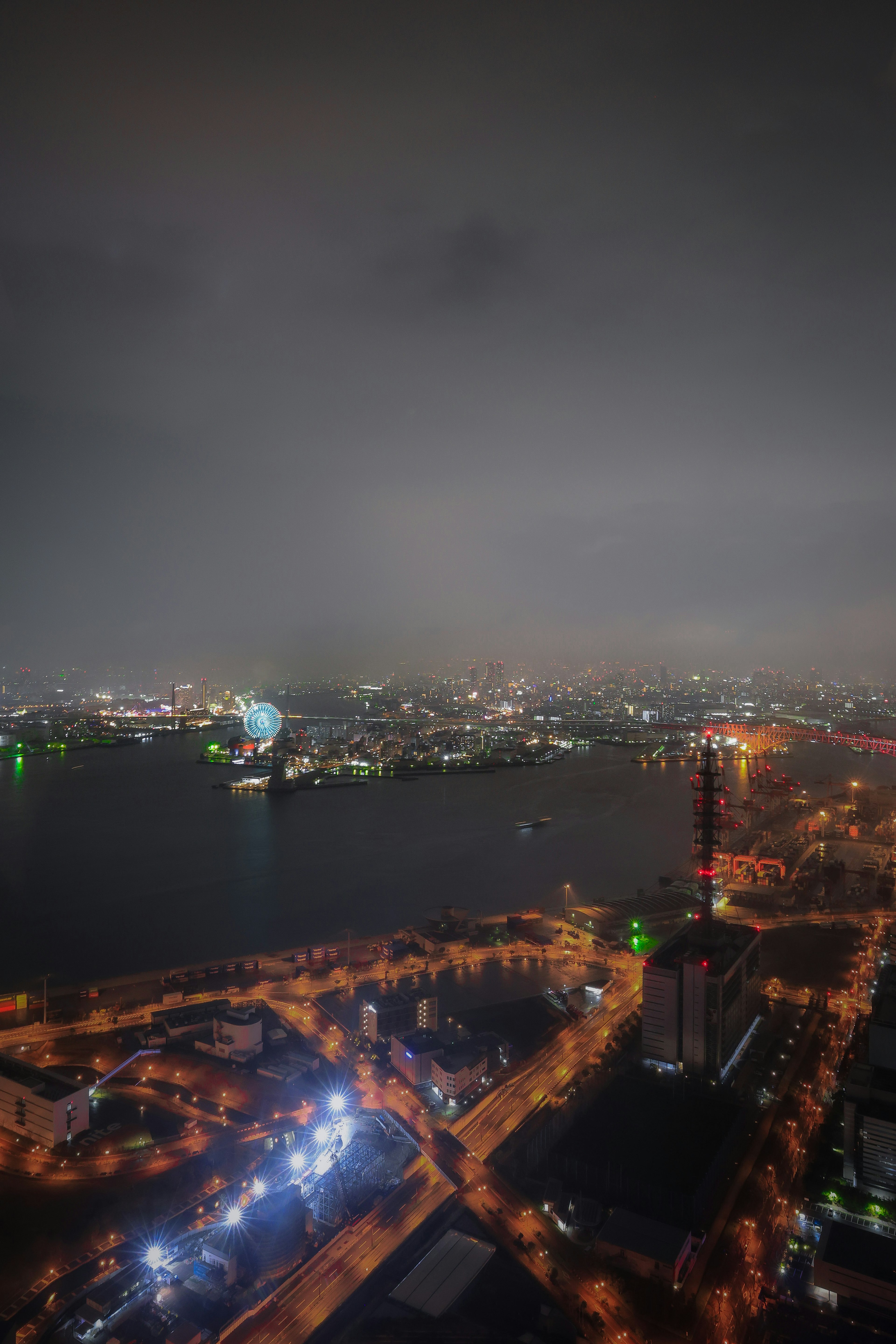 Vista nocturna de un paisaje urbano con un río y farolas brillantes junto con luces verdes