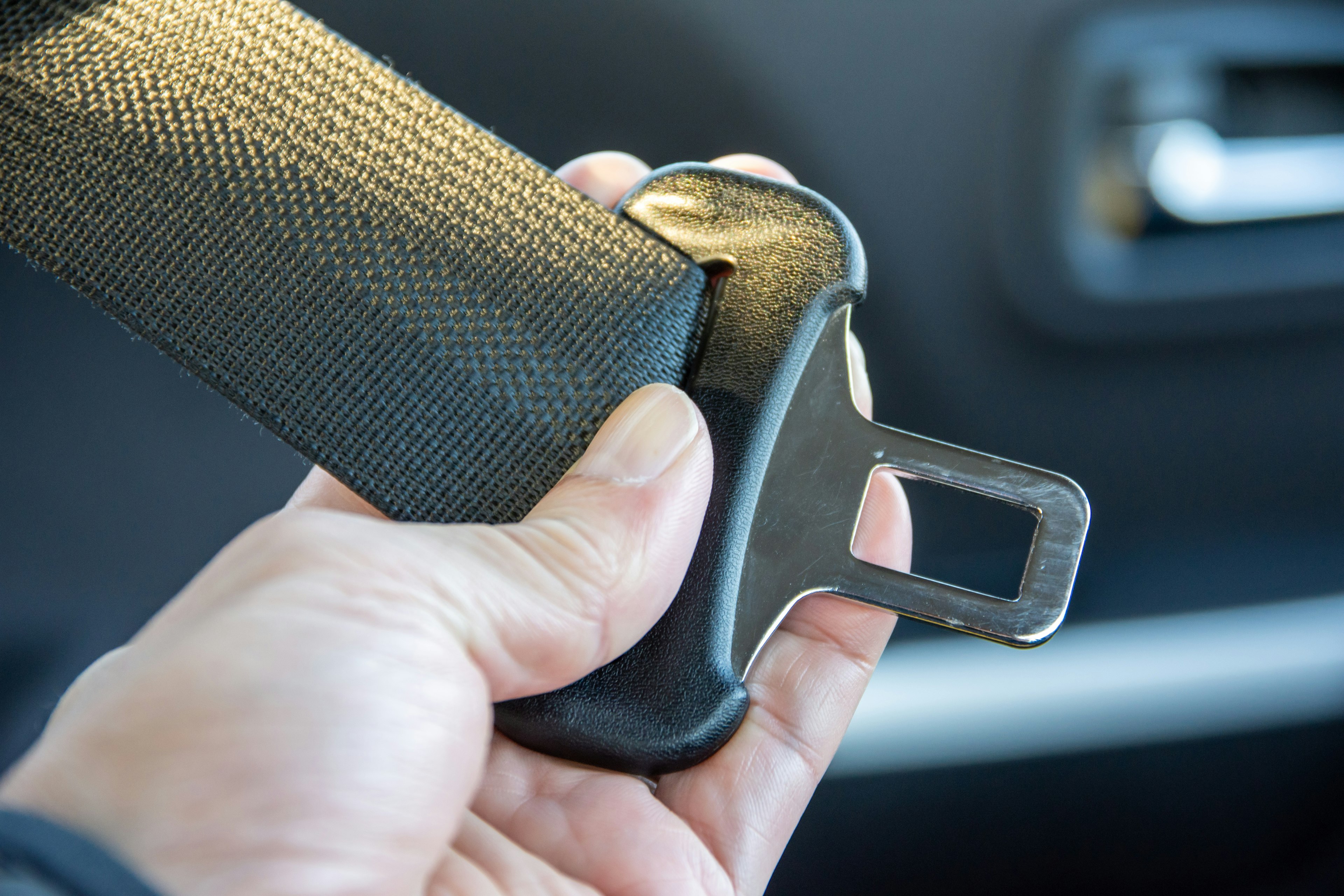 Close-up of a hand holding a car seat belt