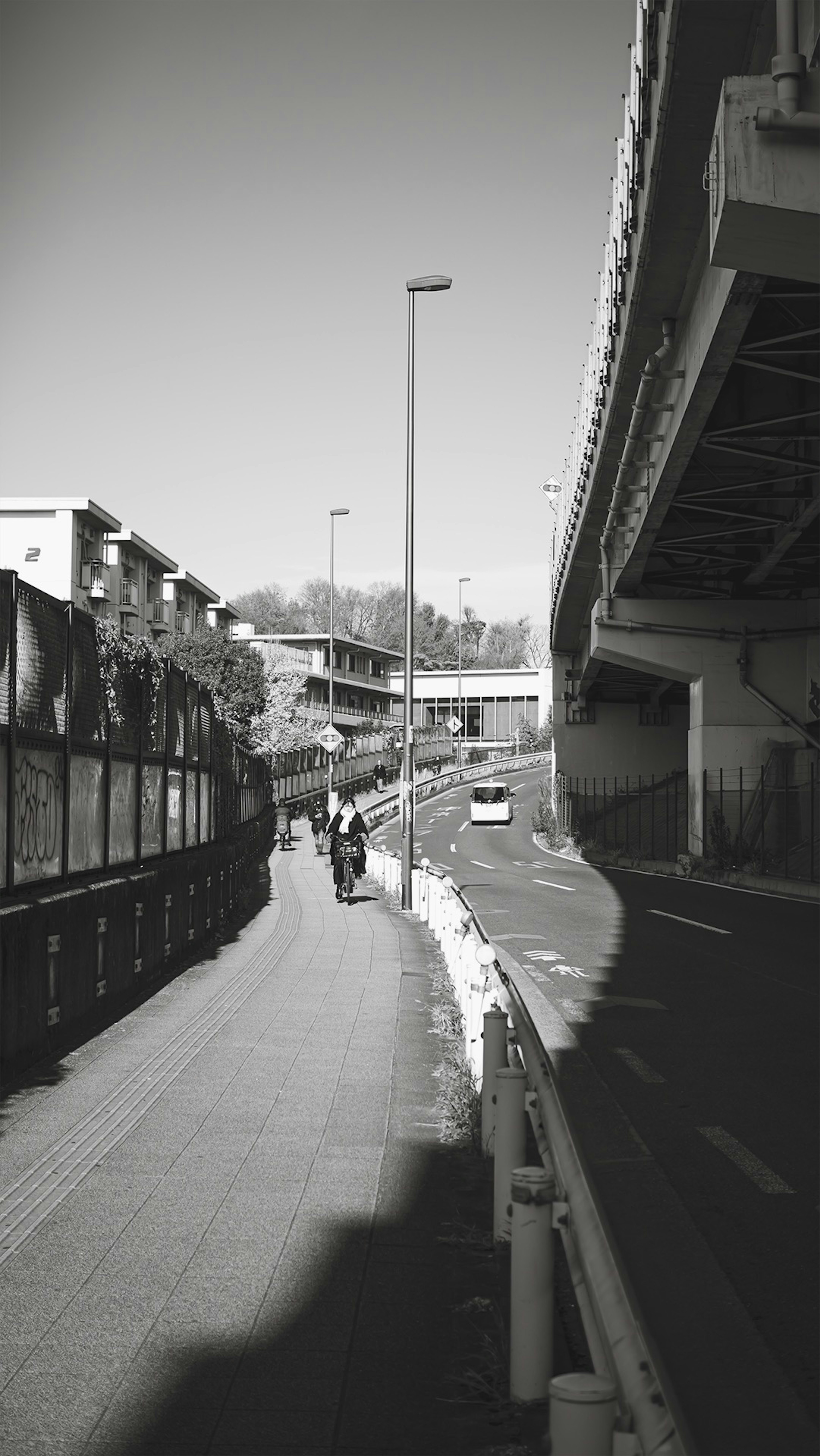 道路沿いの歩道と高架橋の風景