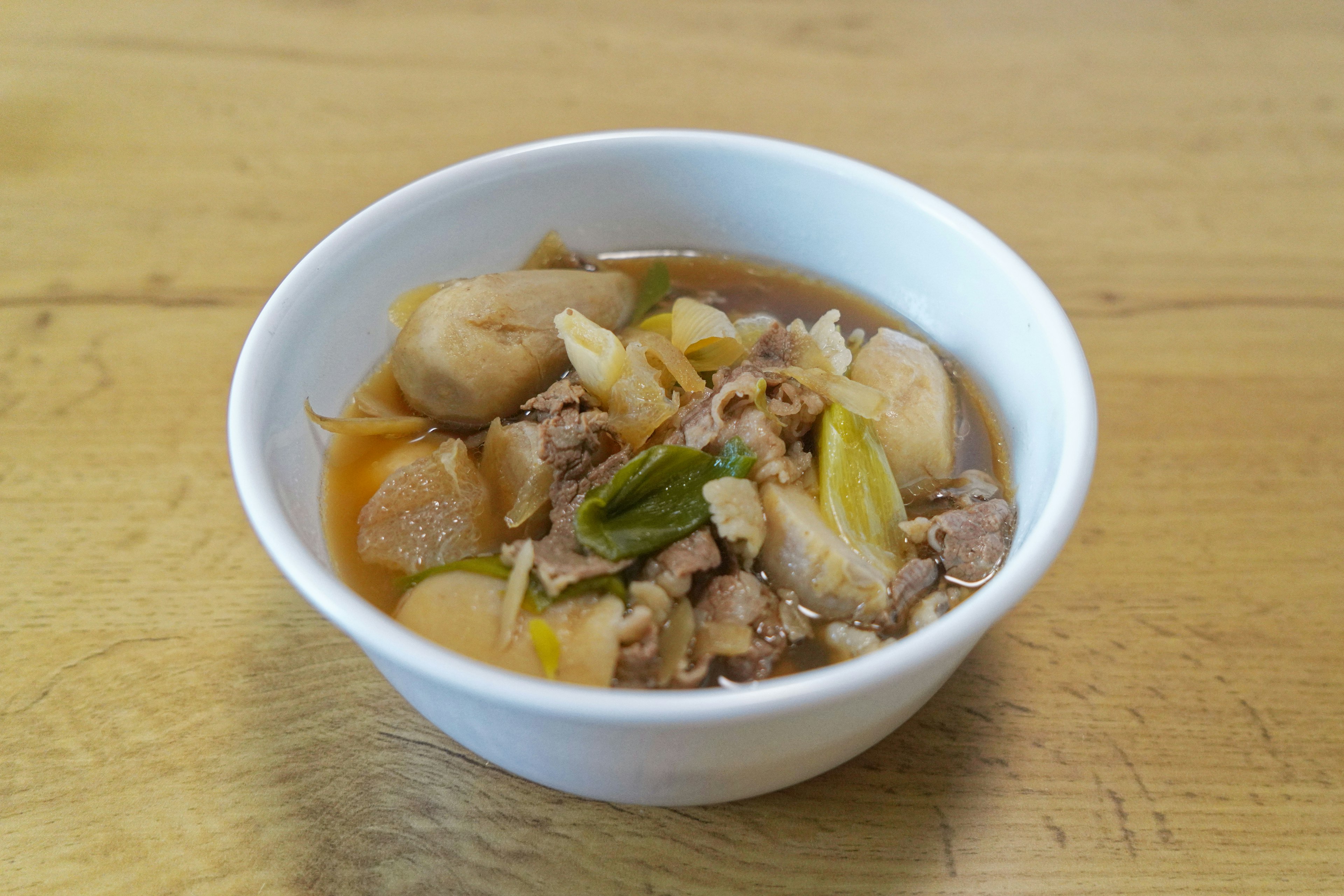 A bowl of soup with meat and vegetables