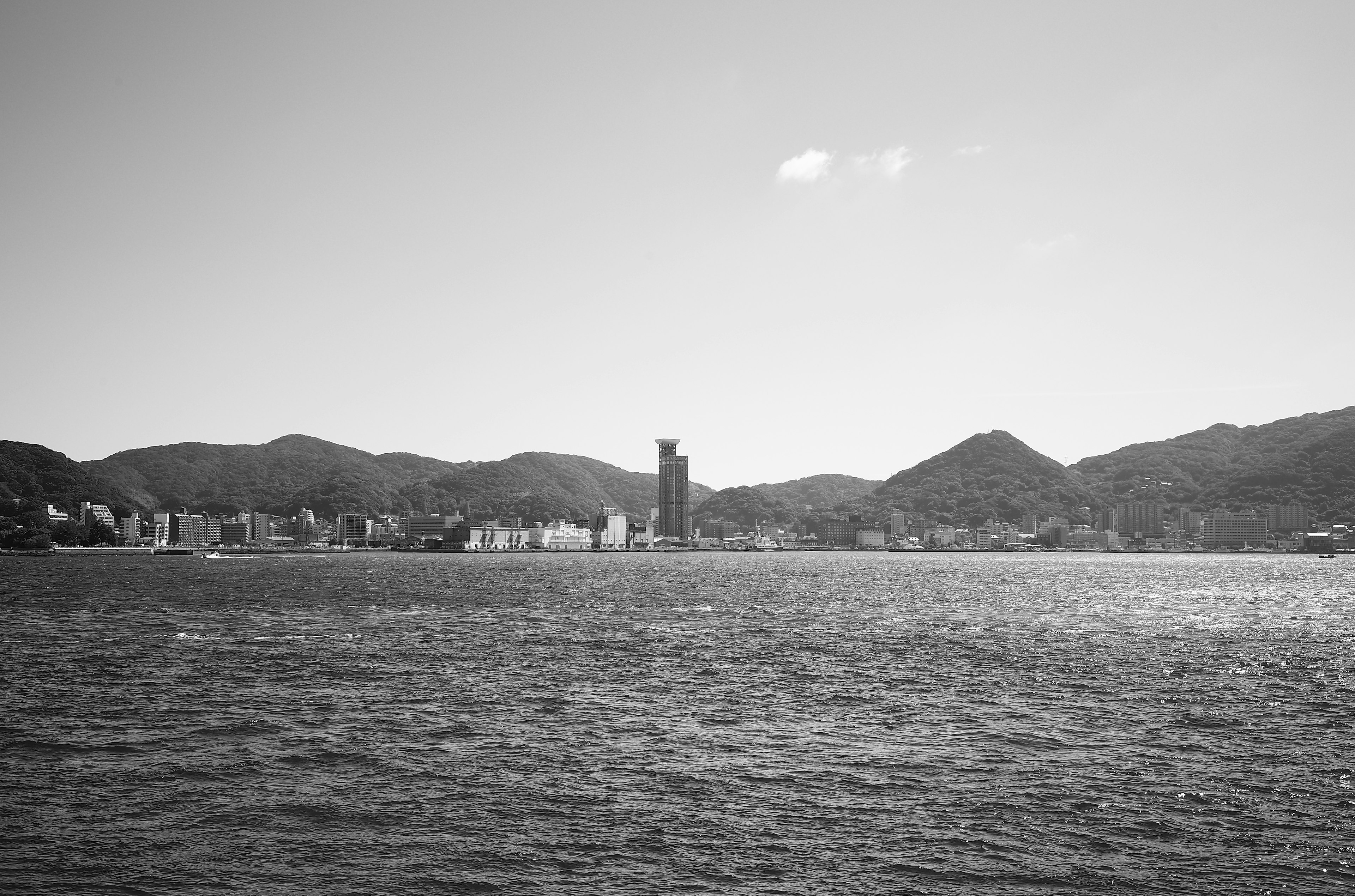 海と山々を背景にした都市の風景 モノクロ写真