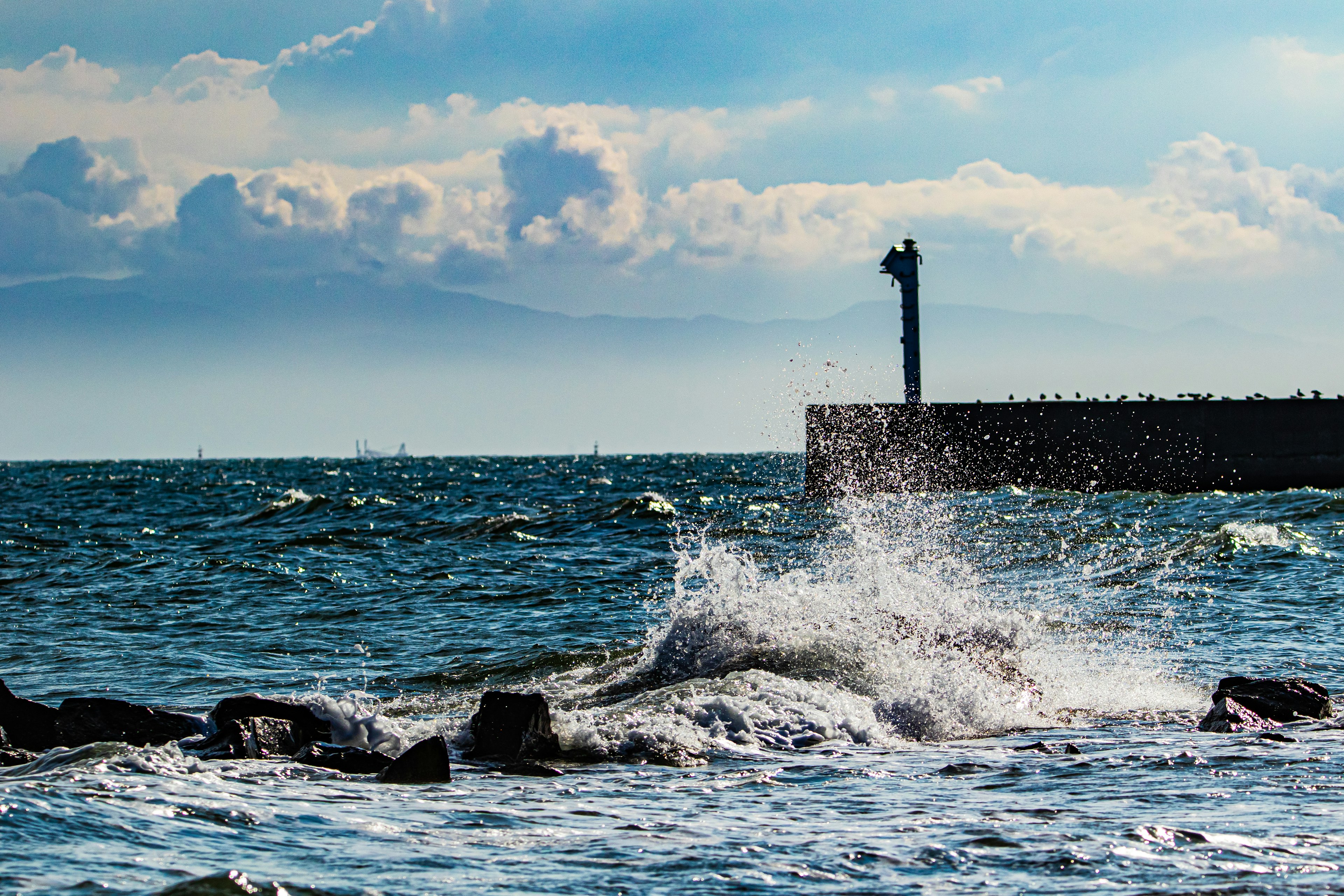 Paysage maritime avec des vagues percutantes et un phare au loin