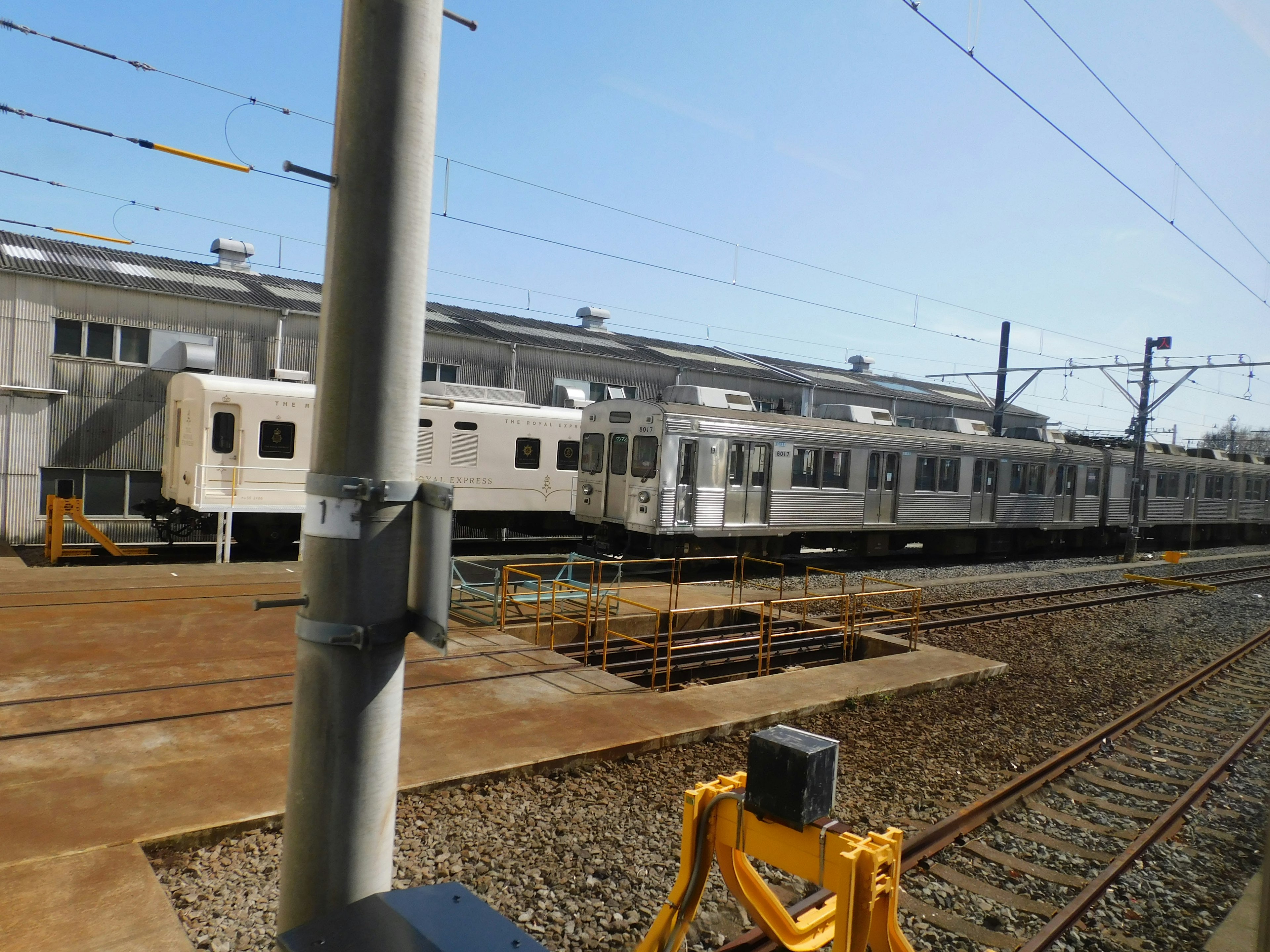 White train parked at a station with blue sky