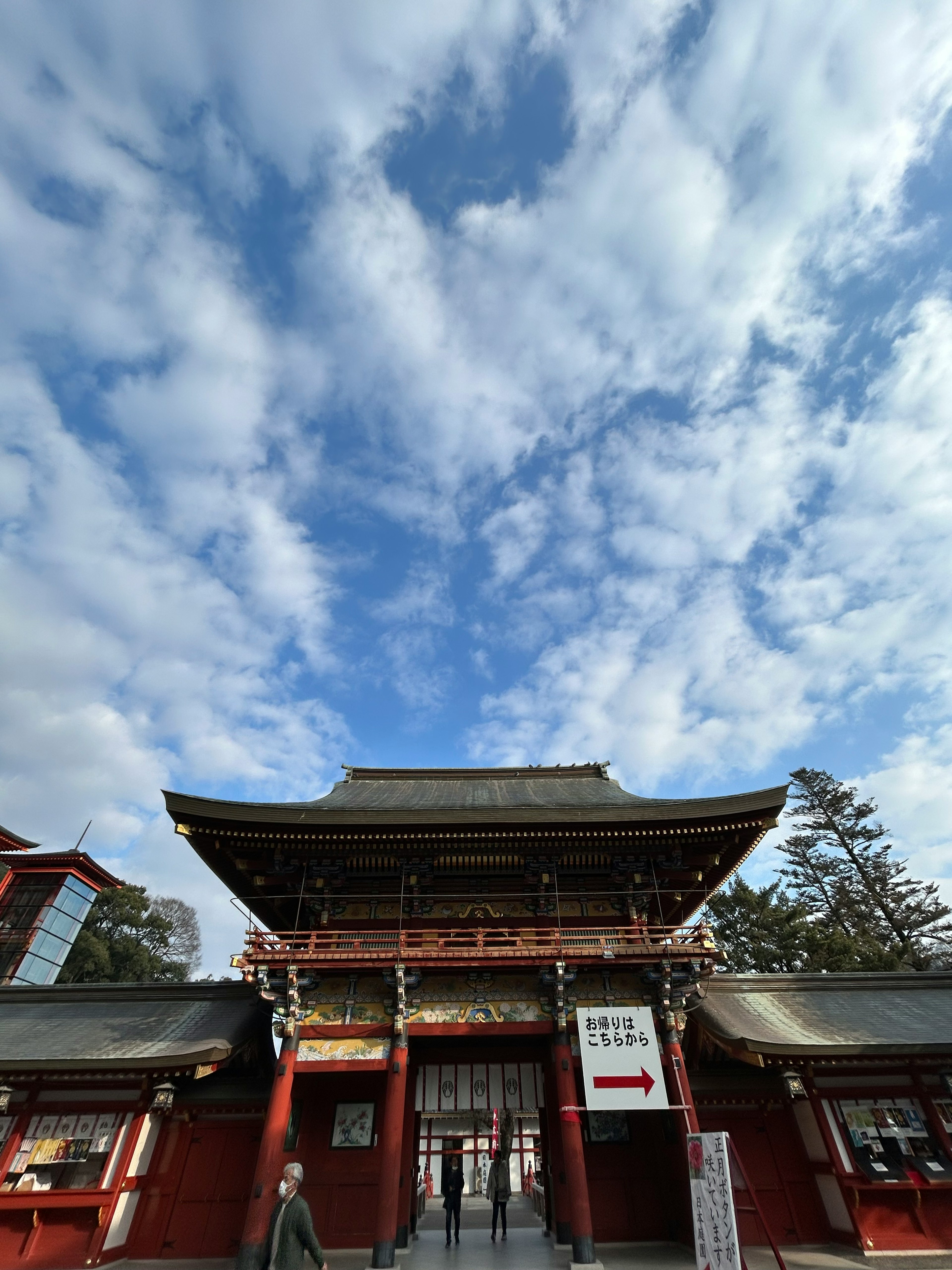 Entrée d'un sanctuaire avec une porte rouge et un ciel bleu