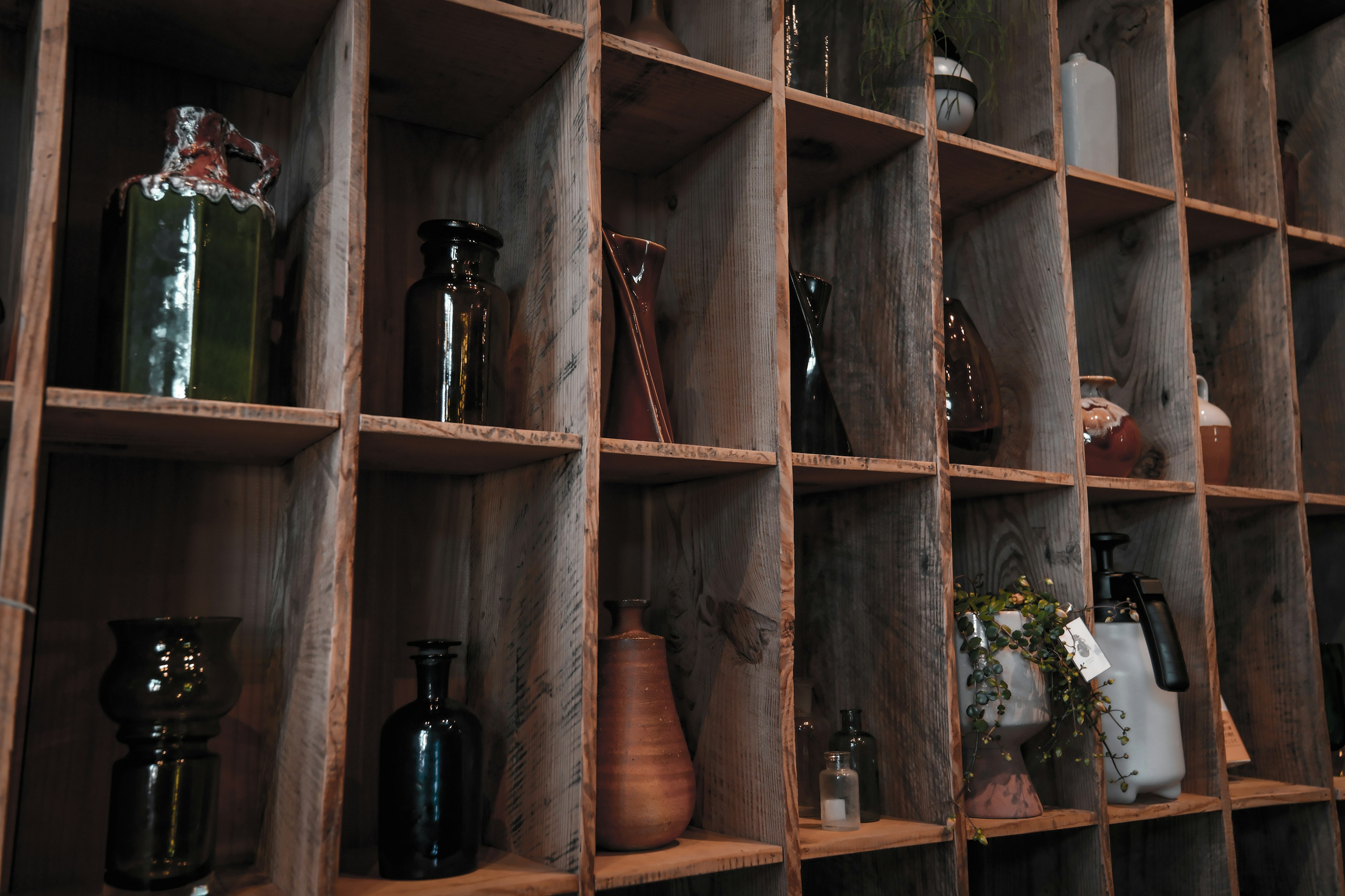 Display of various bottles and containers on a wooden shelf