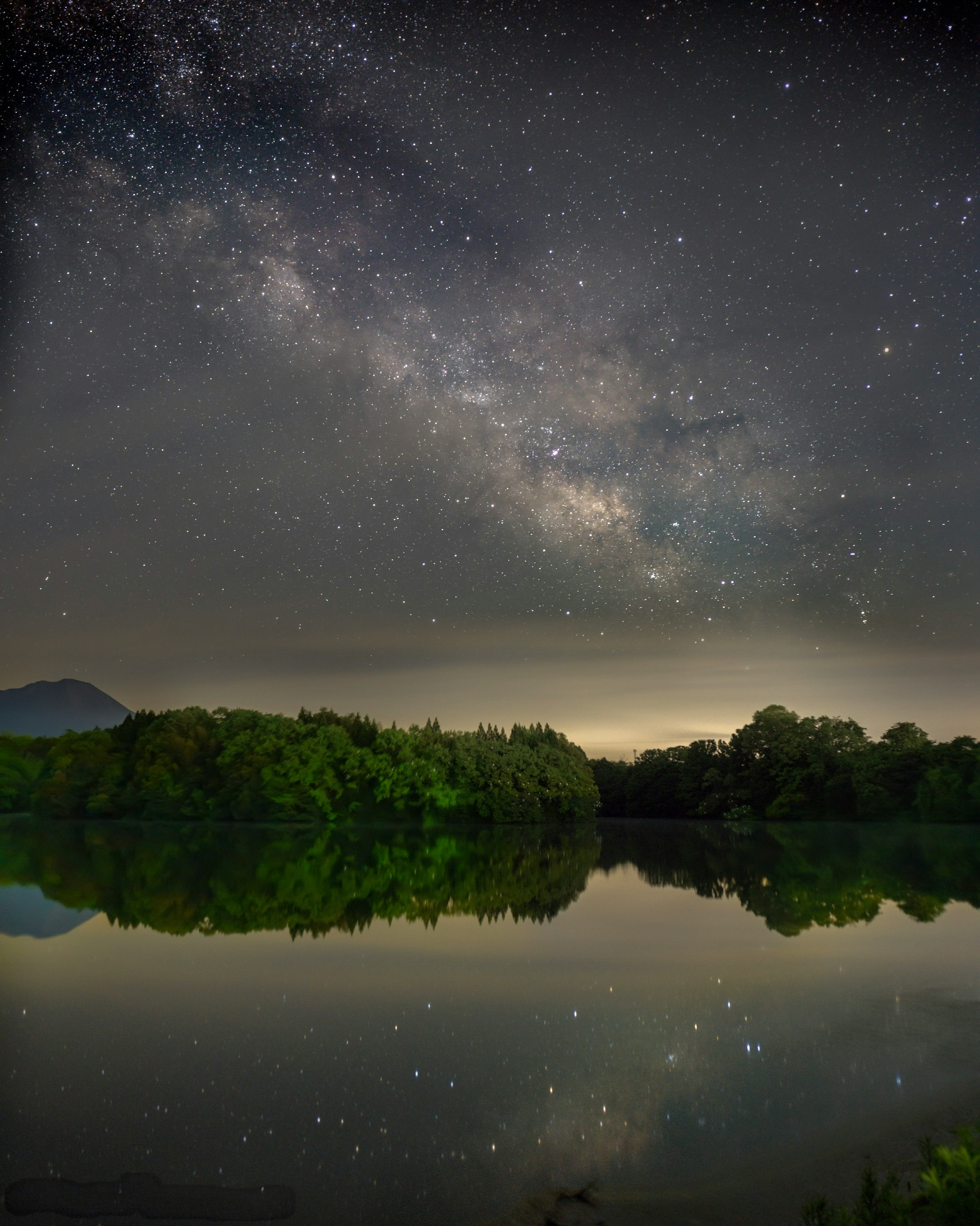 星空とミルキーウェイが映る静かな湖の風景