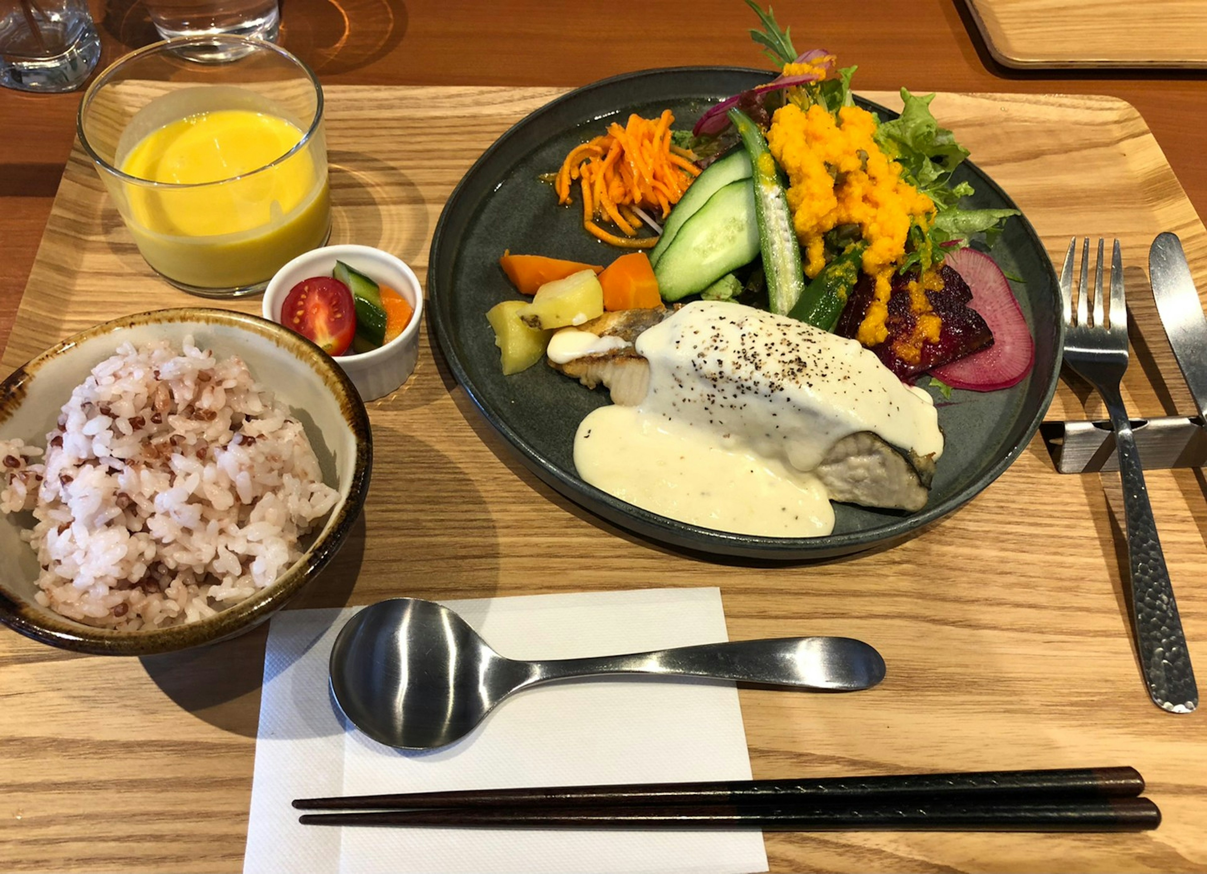 Ein Teller mit einem Gericht aus weißem Fisch und einem bunten Salat mit verschiedenen Gemüsesorten