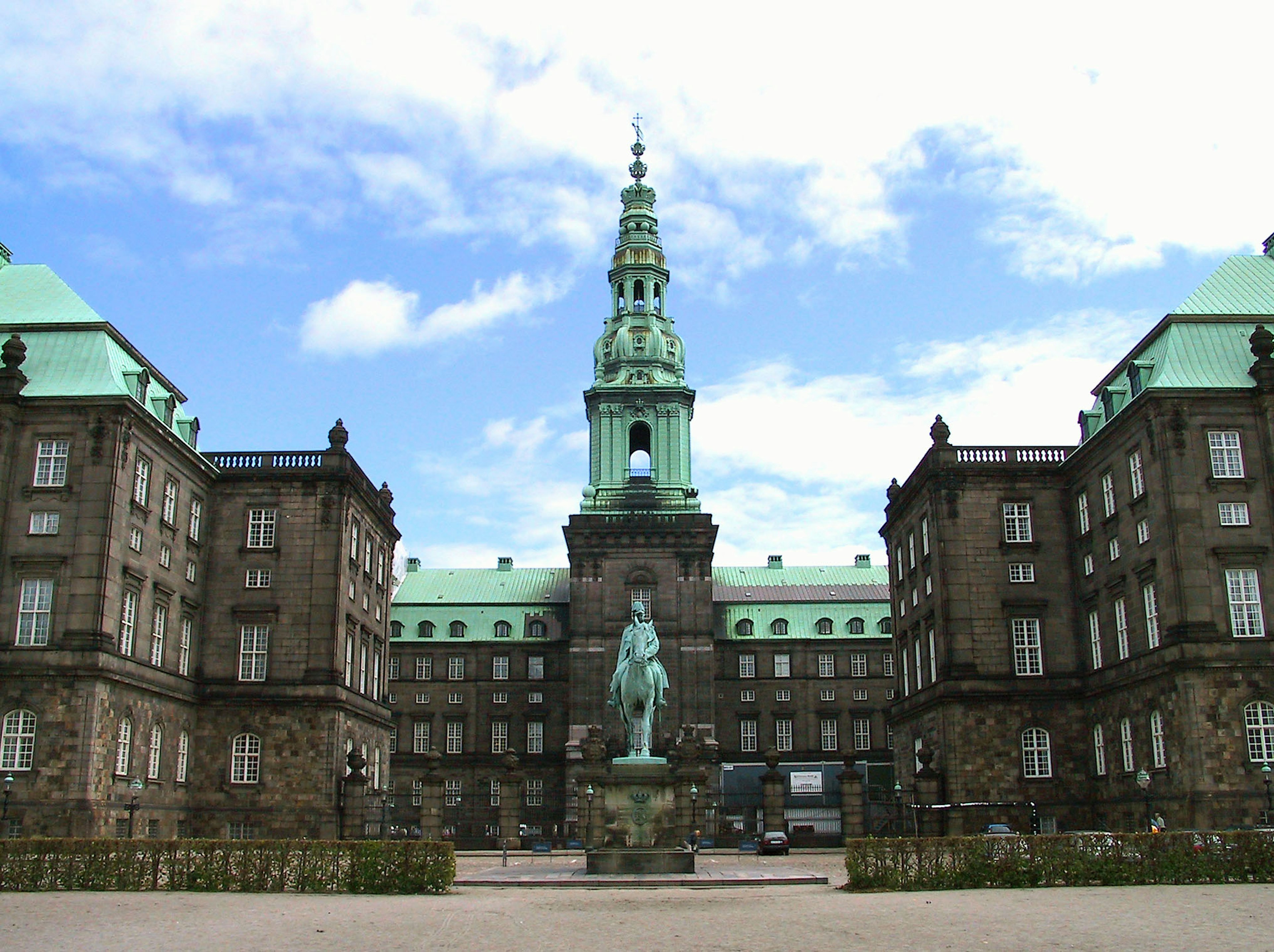 Tampilan luar Istana Christiansborg di Kopenhagen dengan arsitektur megah dan latar belakang langit biru