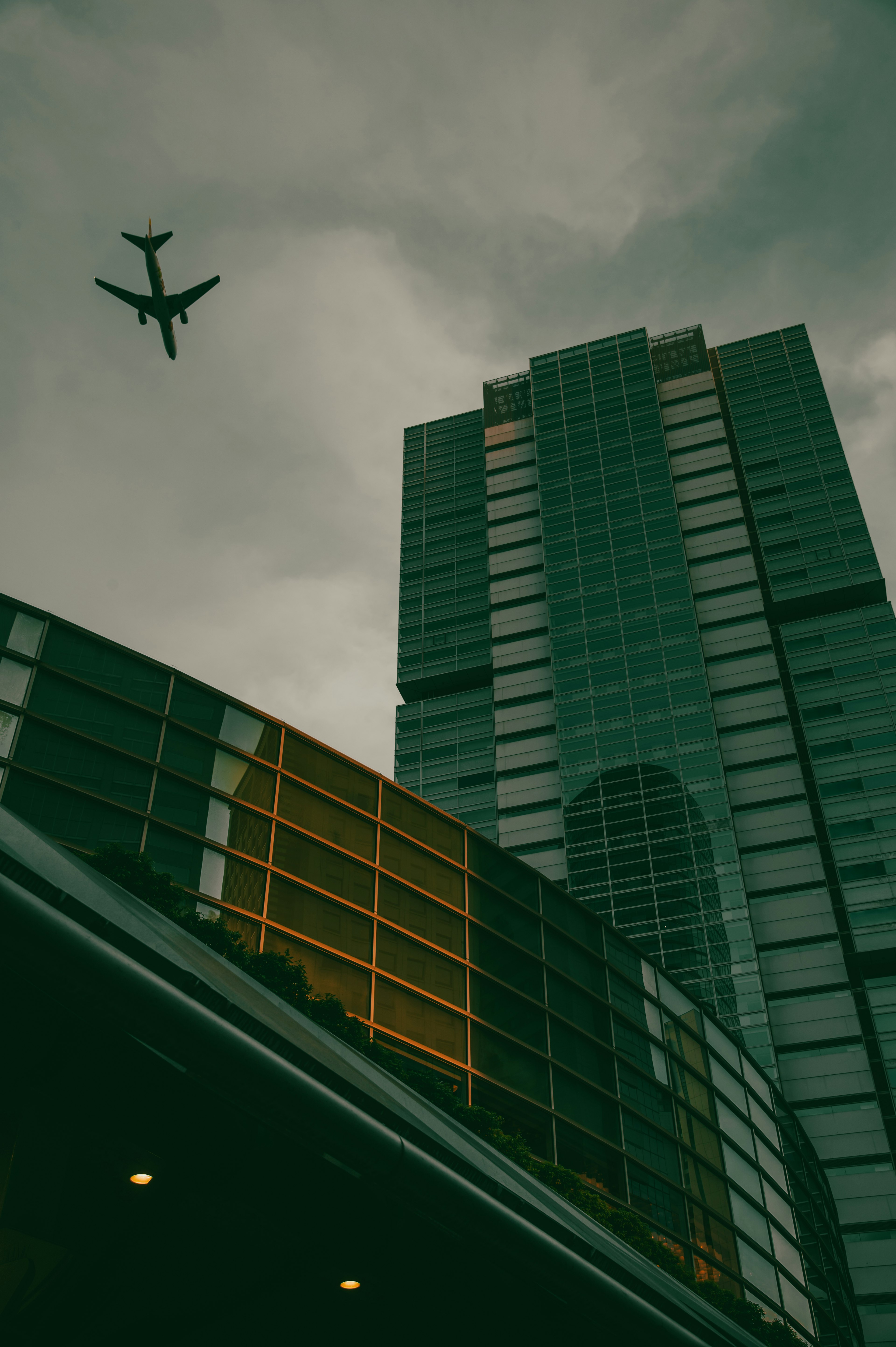 Paisaje urbano con un rascacielos y un avión en el cielo