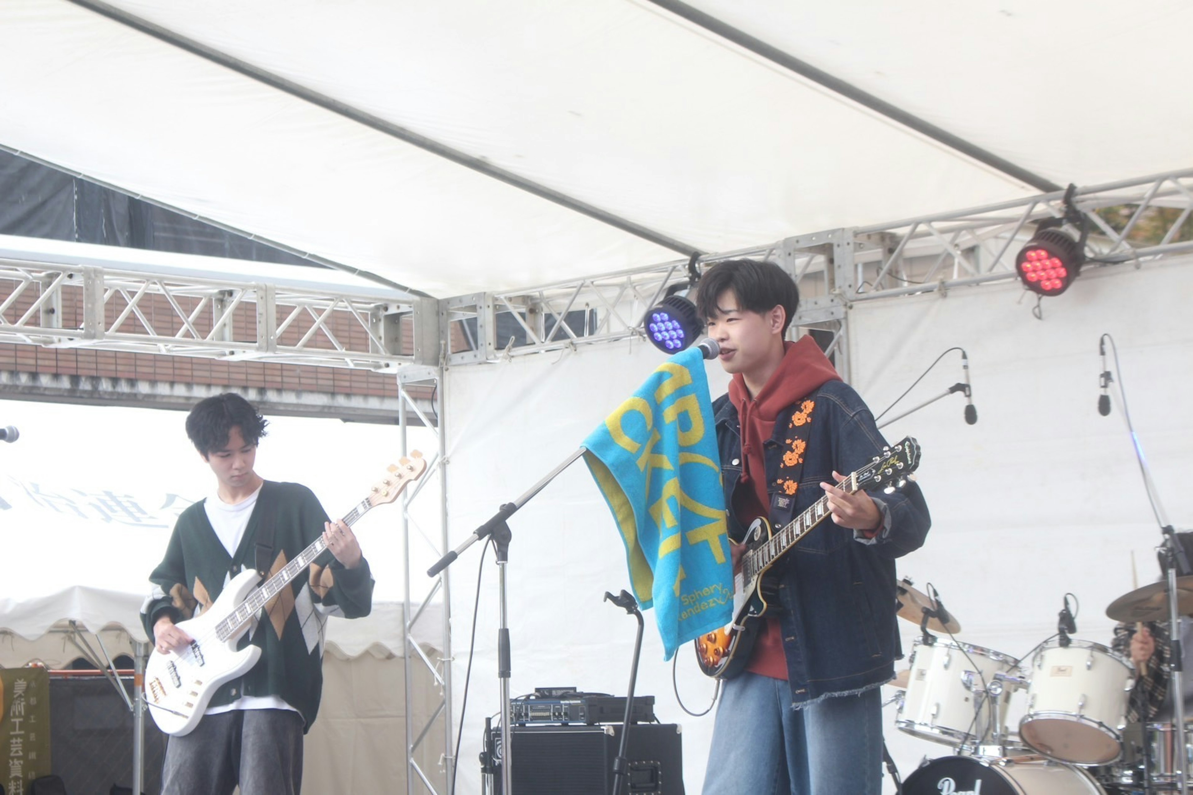 Band members performing live on stage with a flag