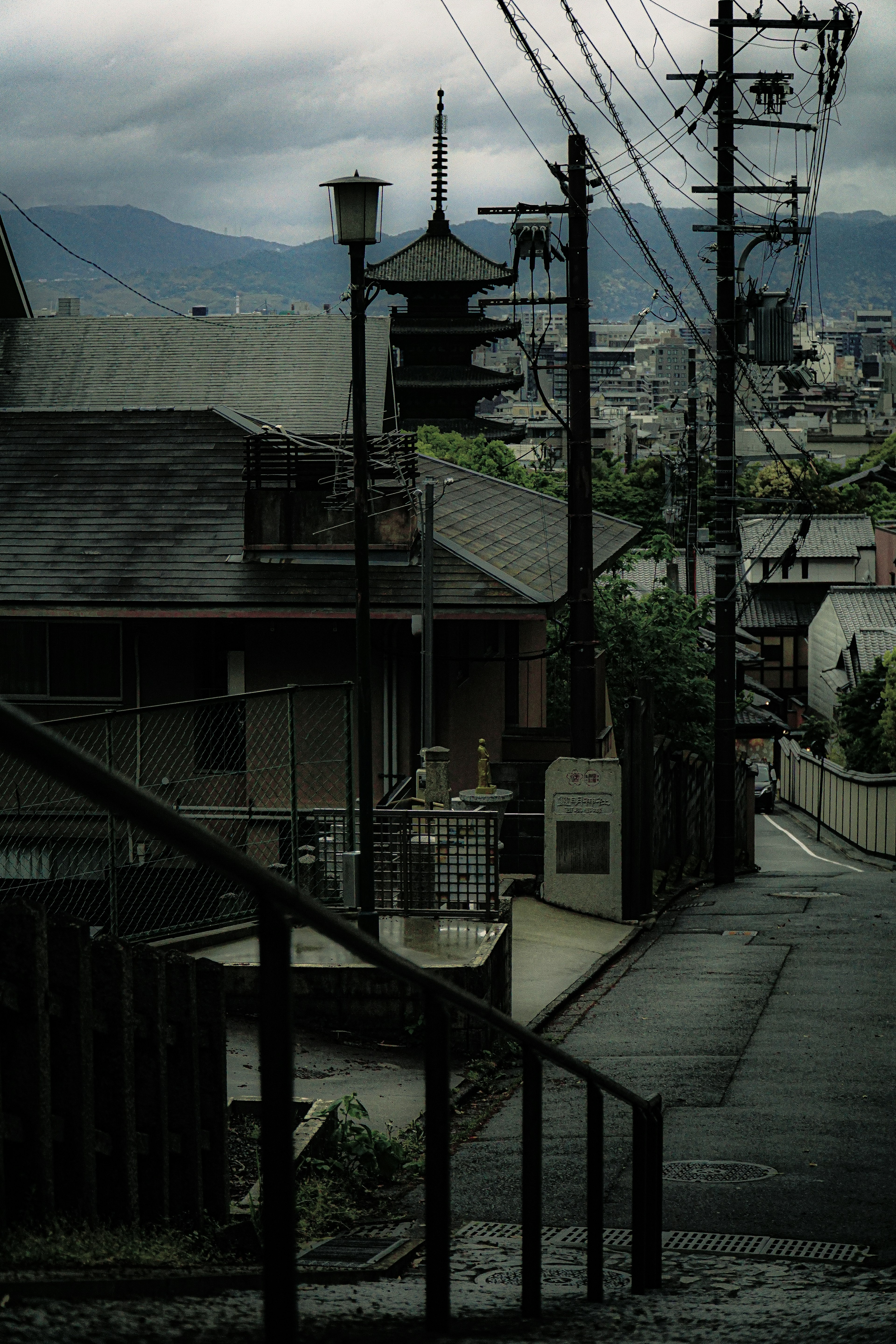 陰雲密布的日本住宅街道 遠處有類似寶塔的建築和電線桿