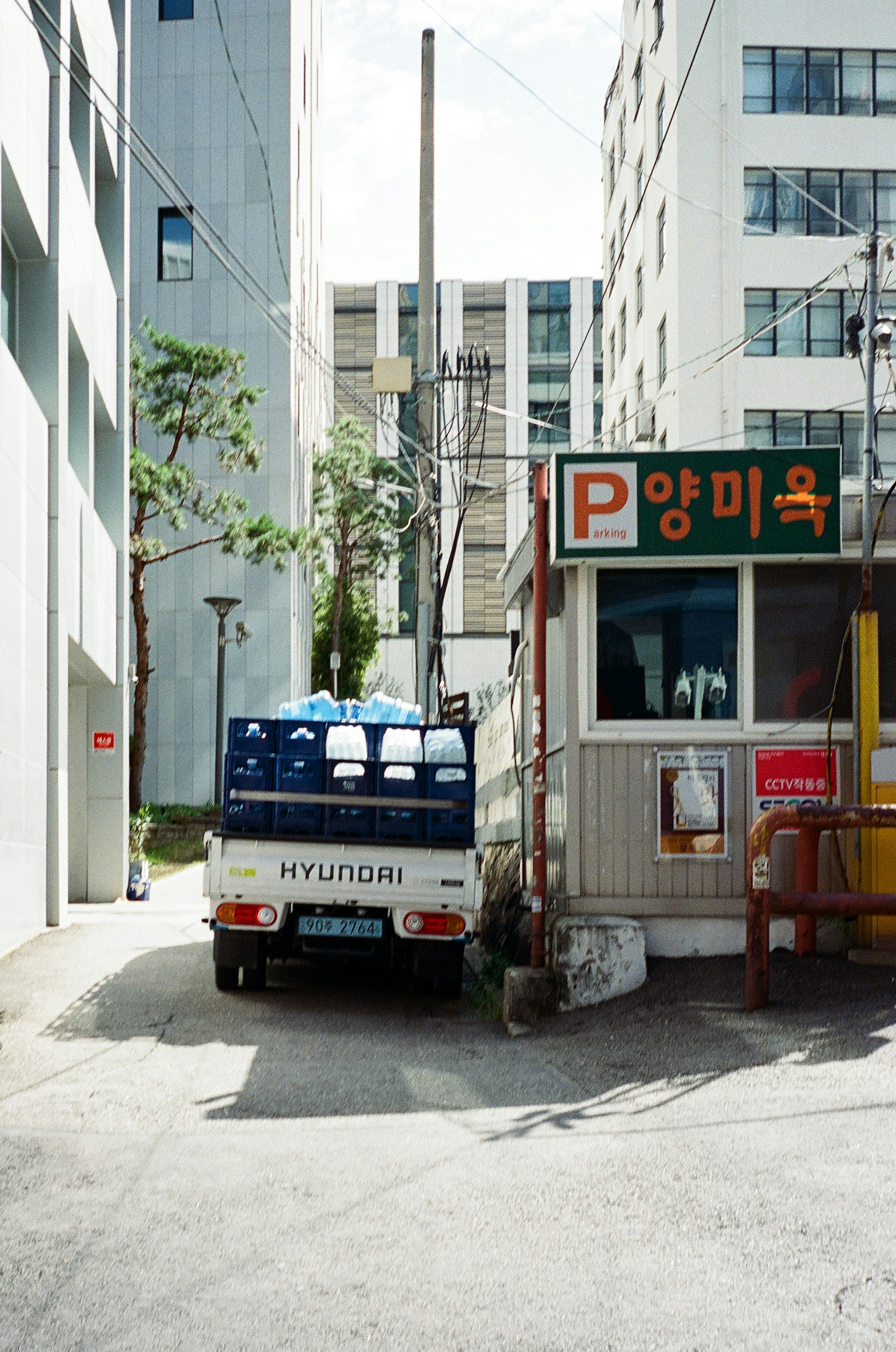 Camión Hyundai estacionado en un callejón estrecho con un cartel de estacionamiento