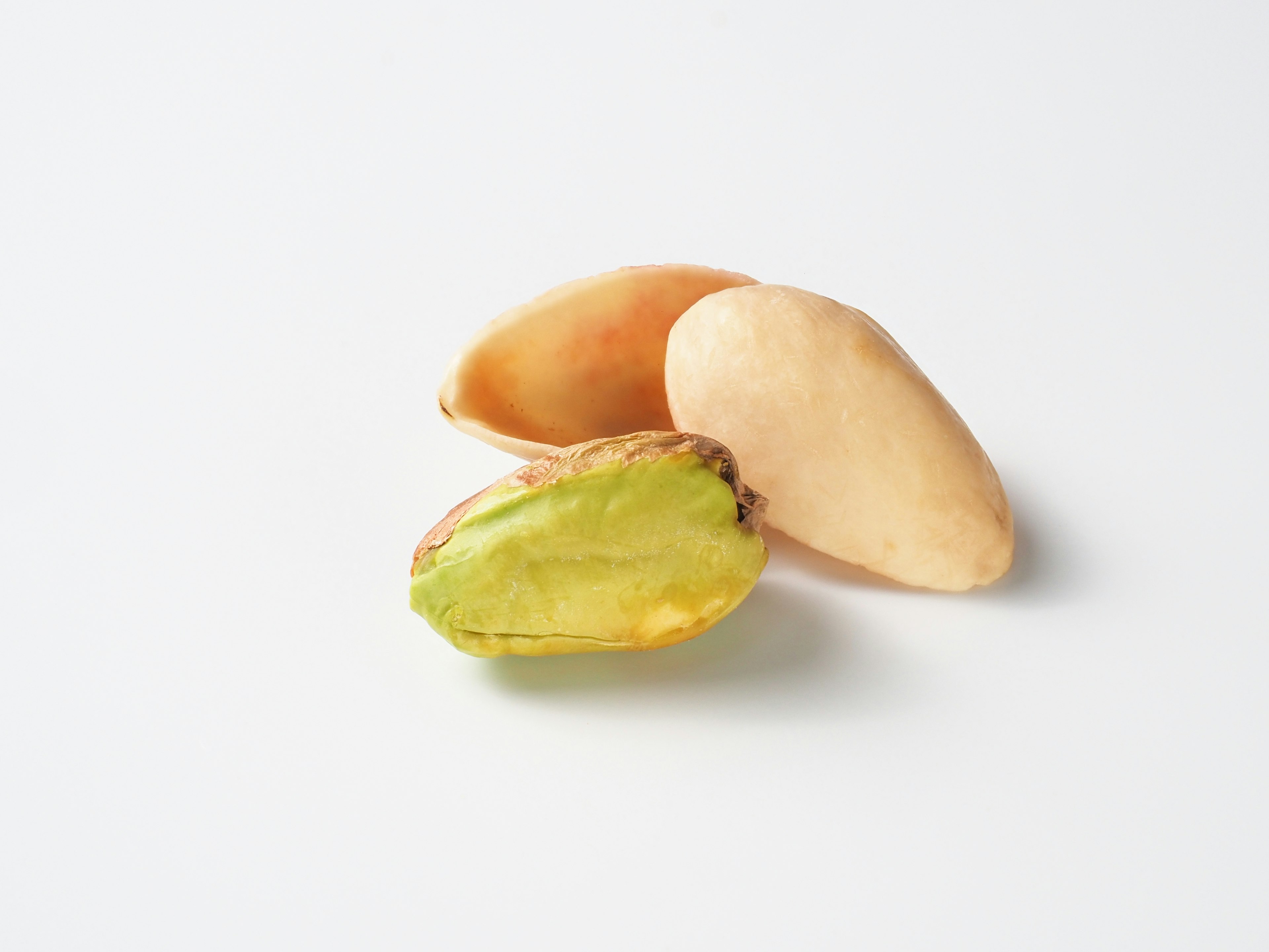 Image of pistachio shells and nut Shells are light orange and the nut is green