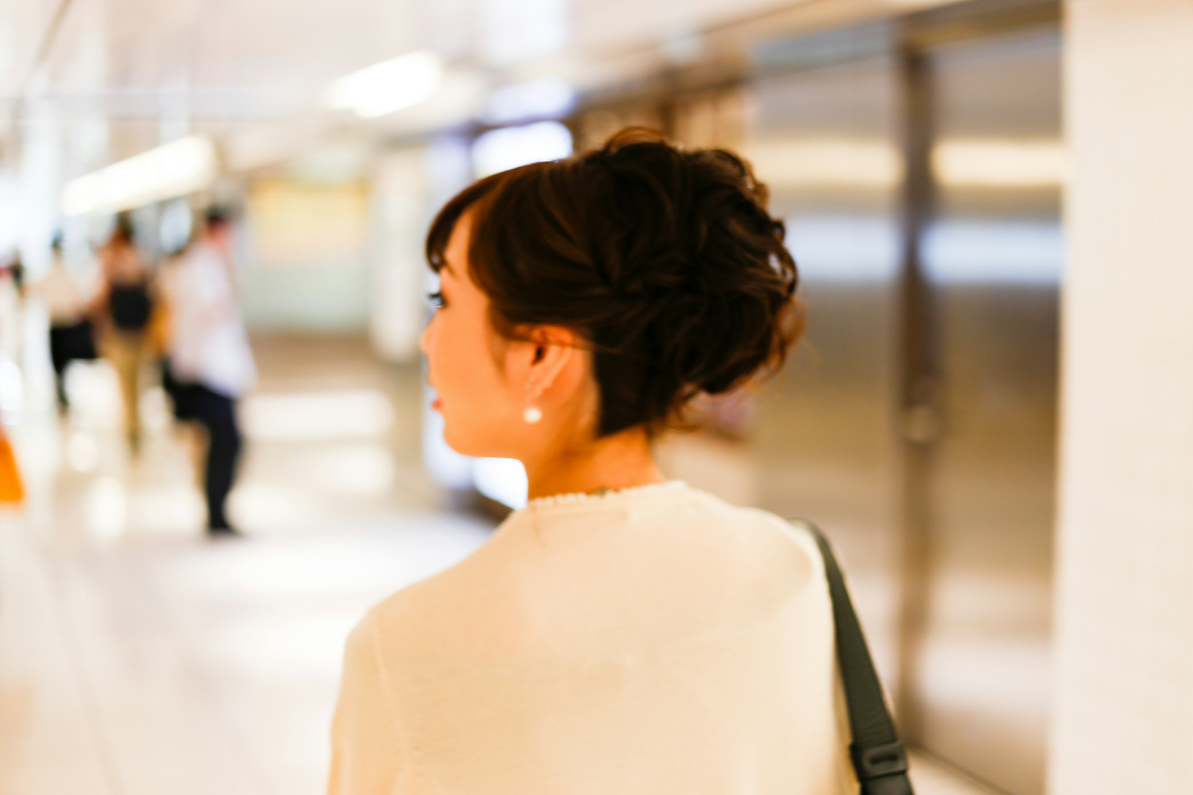 Donna vista di spalle in una stazione abbigliamento casual e acconciatura elegante