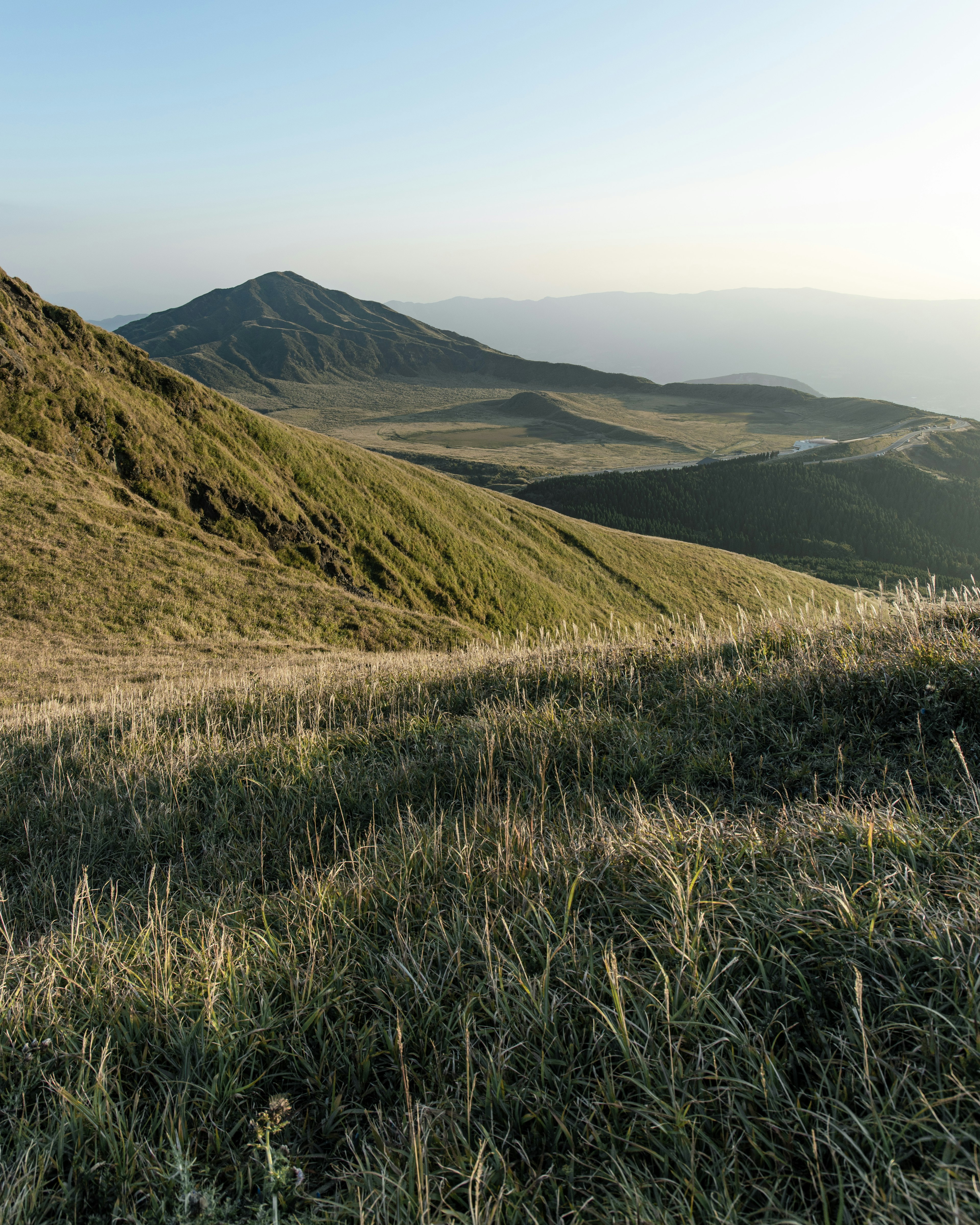 緑の丘と山の風景 日光が当たる草原