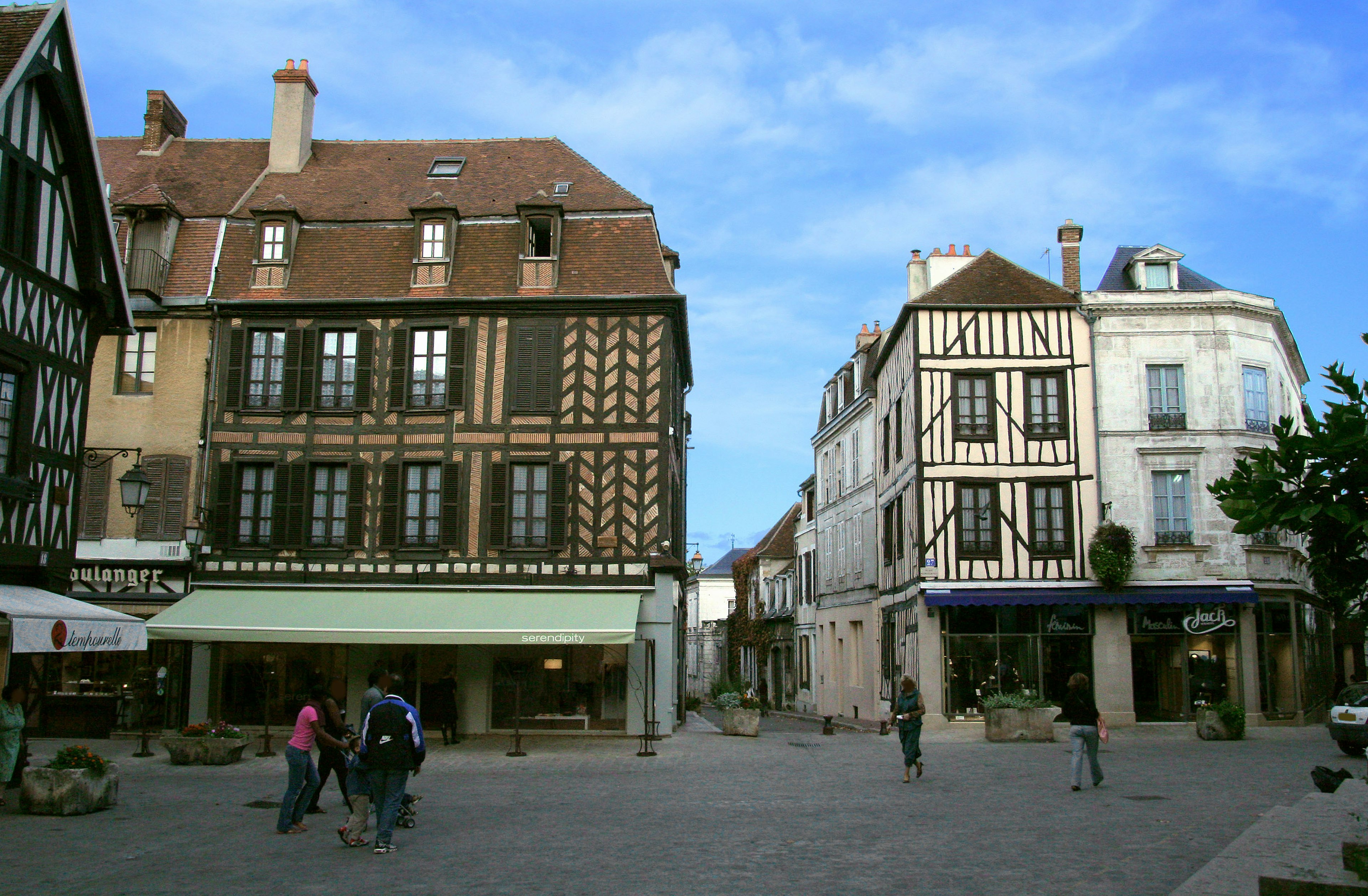 A picturesque square in France featuring traditional half-timbered houses and modern architecture