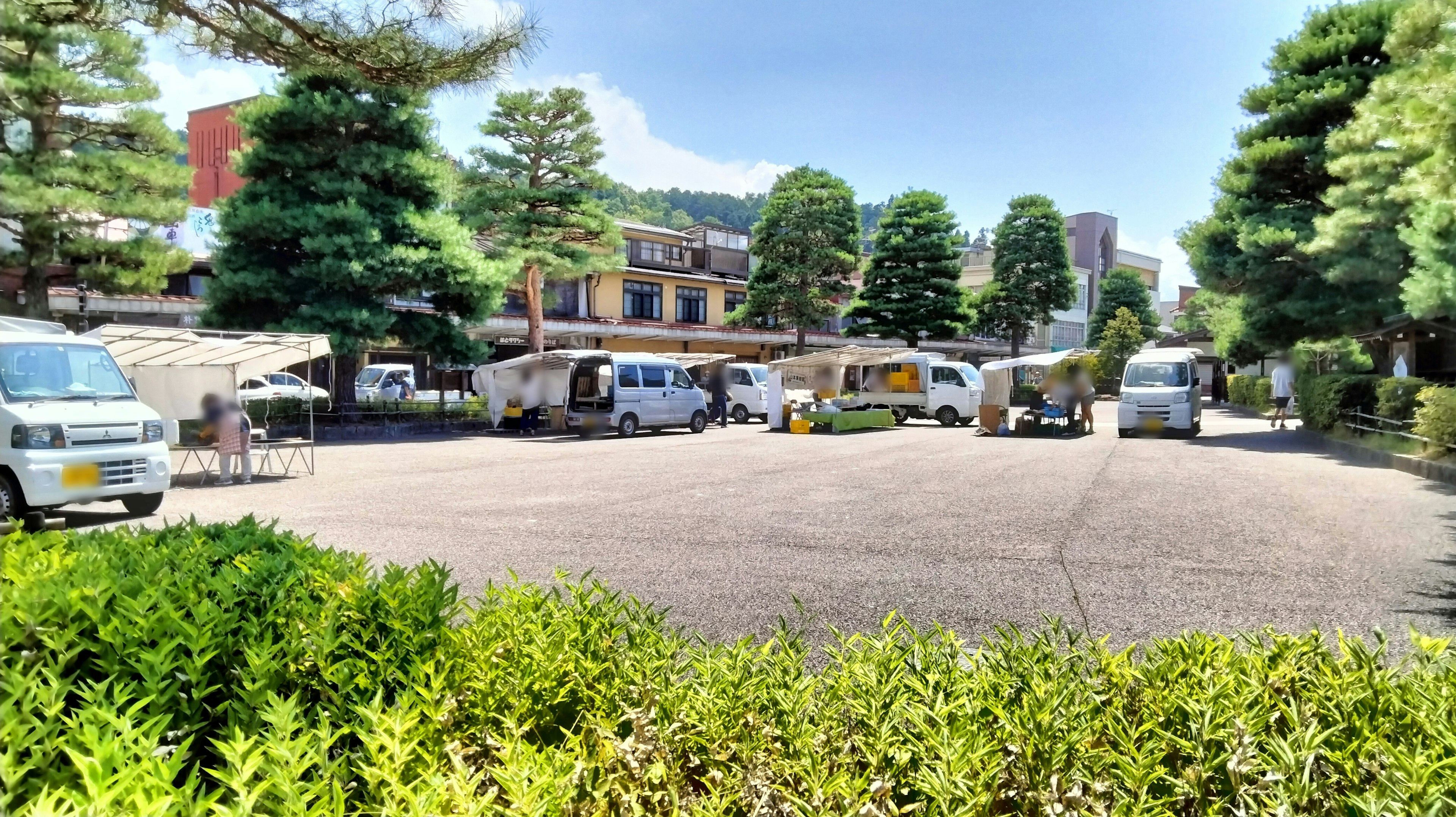 Vue pittoresque d'une aire de stationnement pour camping-cars avec une verdure luxuriante et des bâtiments