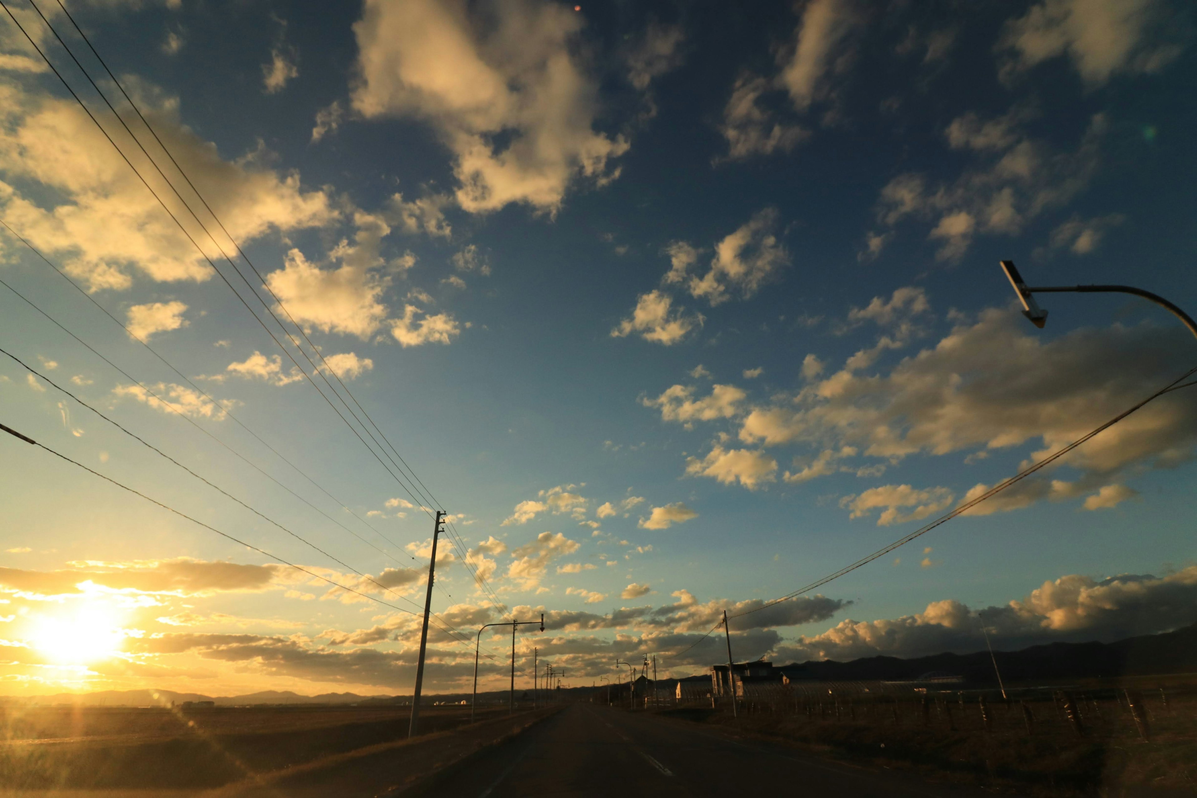 Sonnenuntergangshimmel mit Wolken und Straße