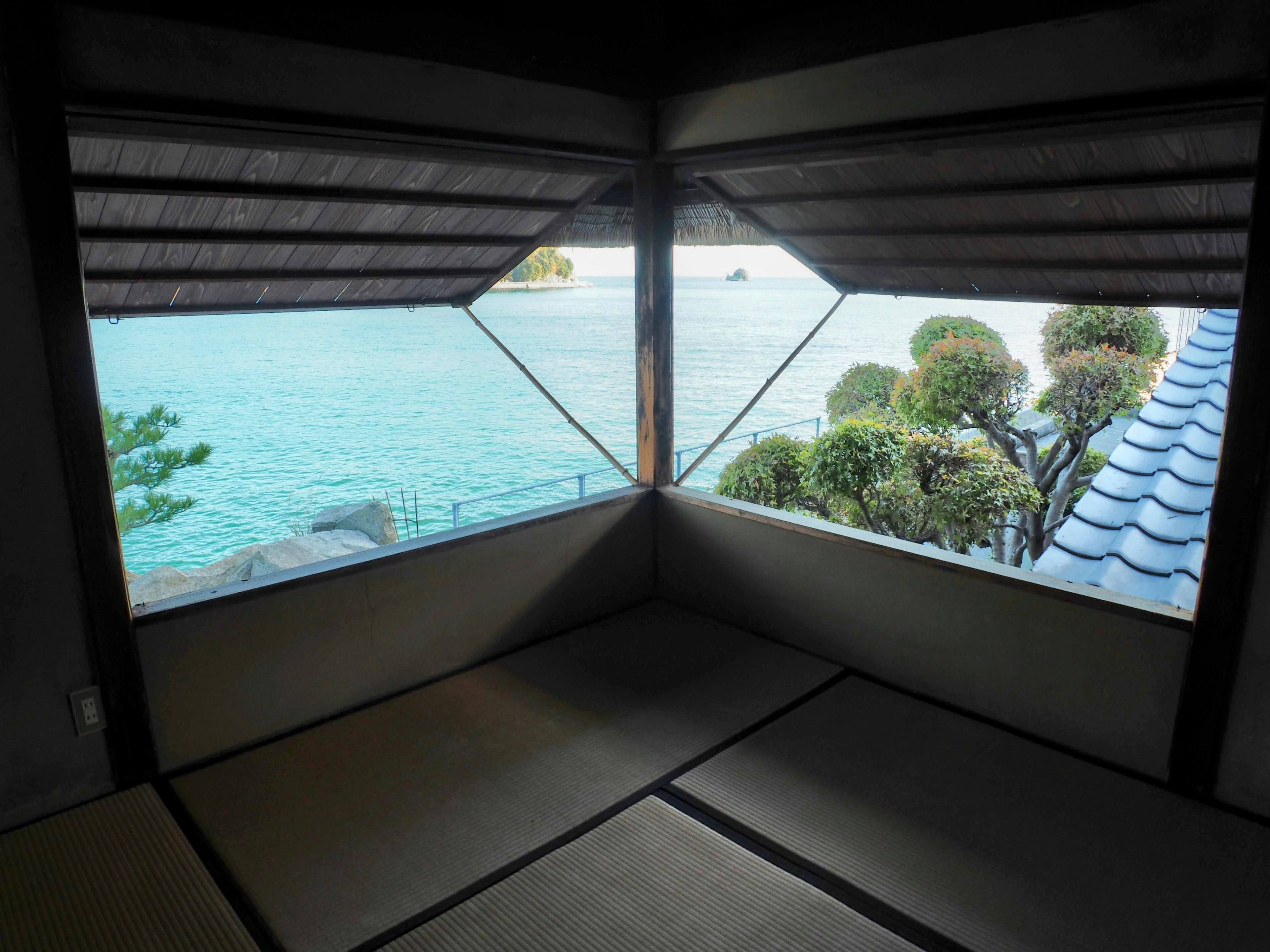 Vista desde una habitación japonesa tradicional con vista al mar y vegetación