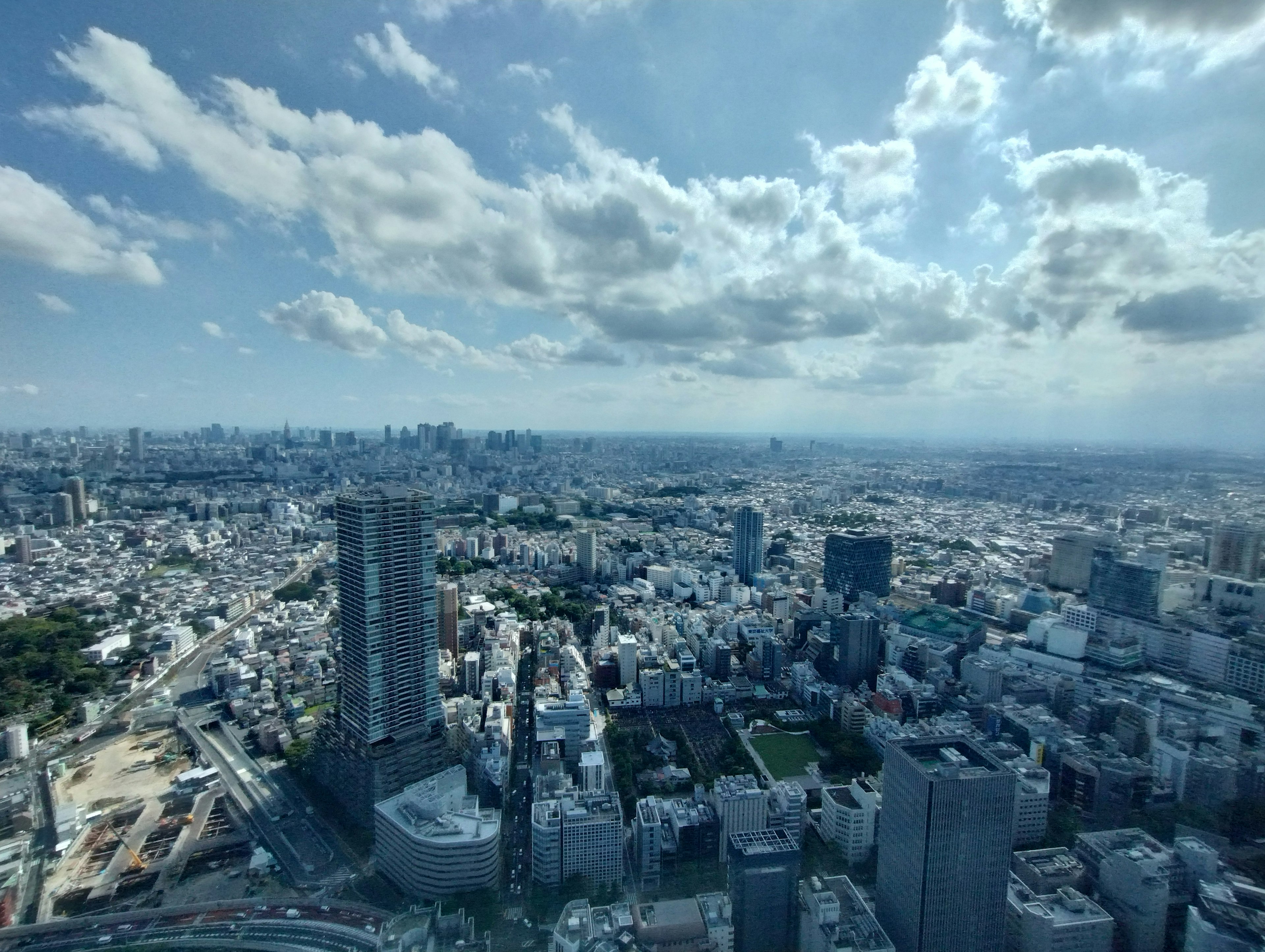 Panoramic view of city skyline with tall buildings under a blue sky