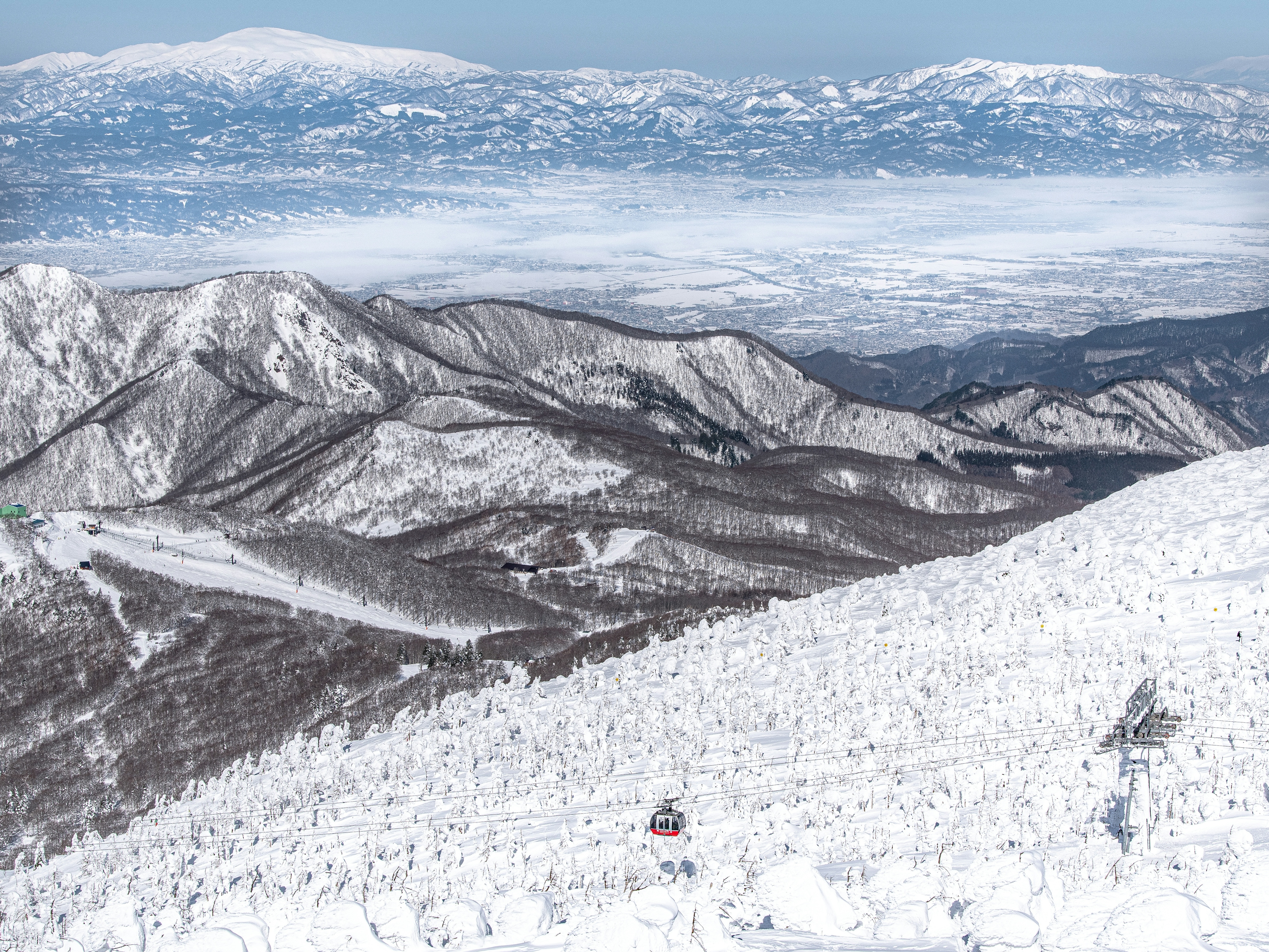 雪に覆われた山々とスキーリフトの風景