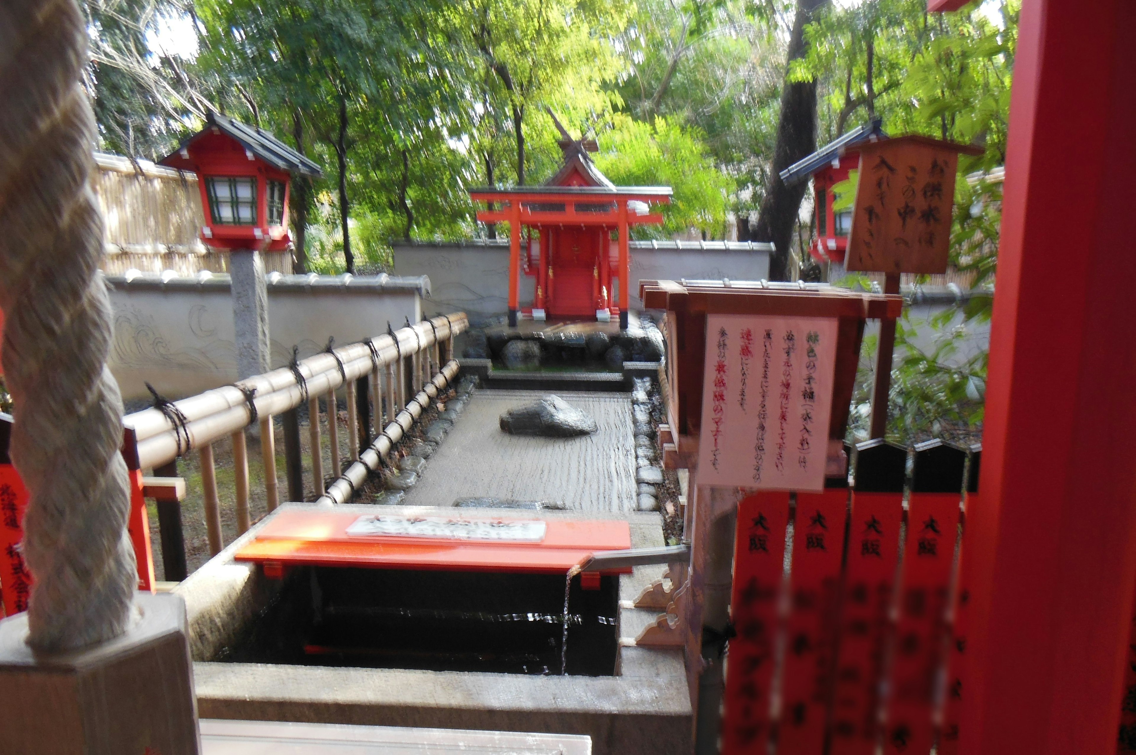 红色神社水池被郁郁葱葱的绿树环绕