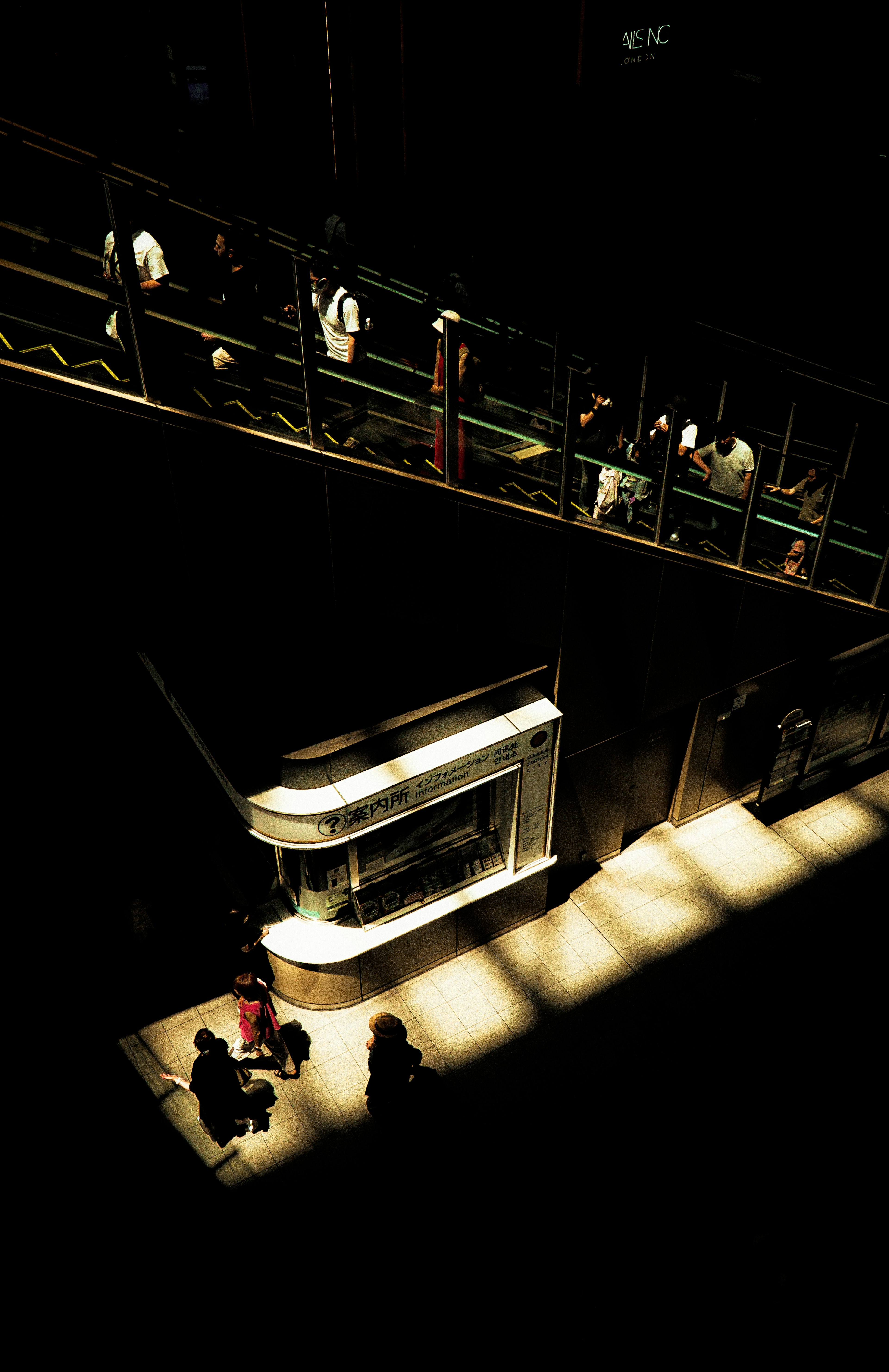 Bright counter in a dark space with people walking above