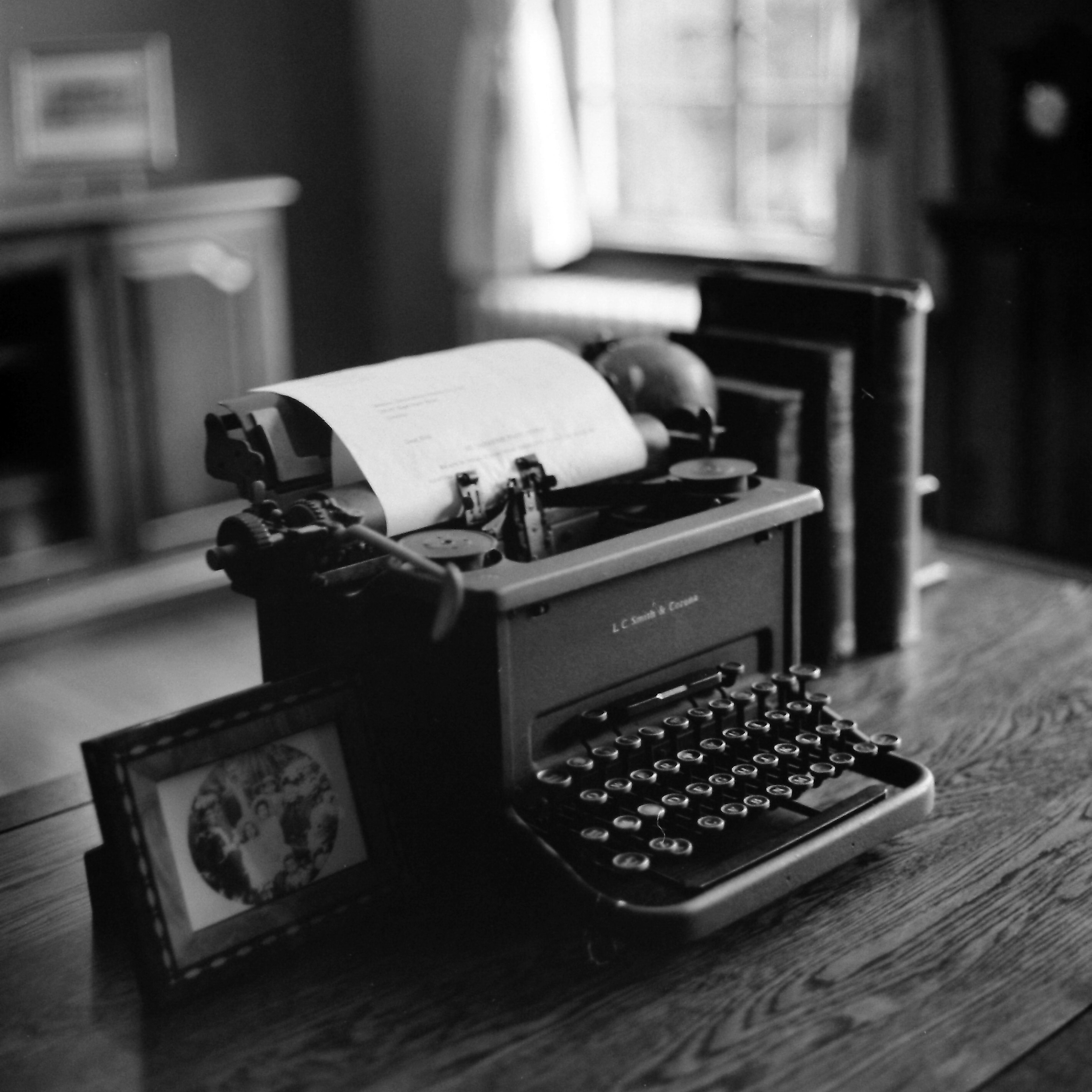 Una máquina de escribir vintage sobre una mesa de madera en una habitación acogedora