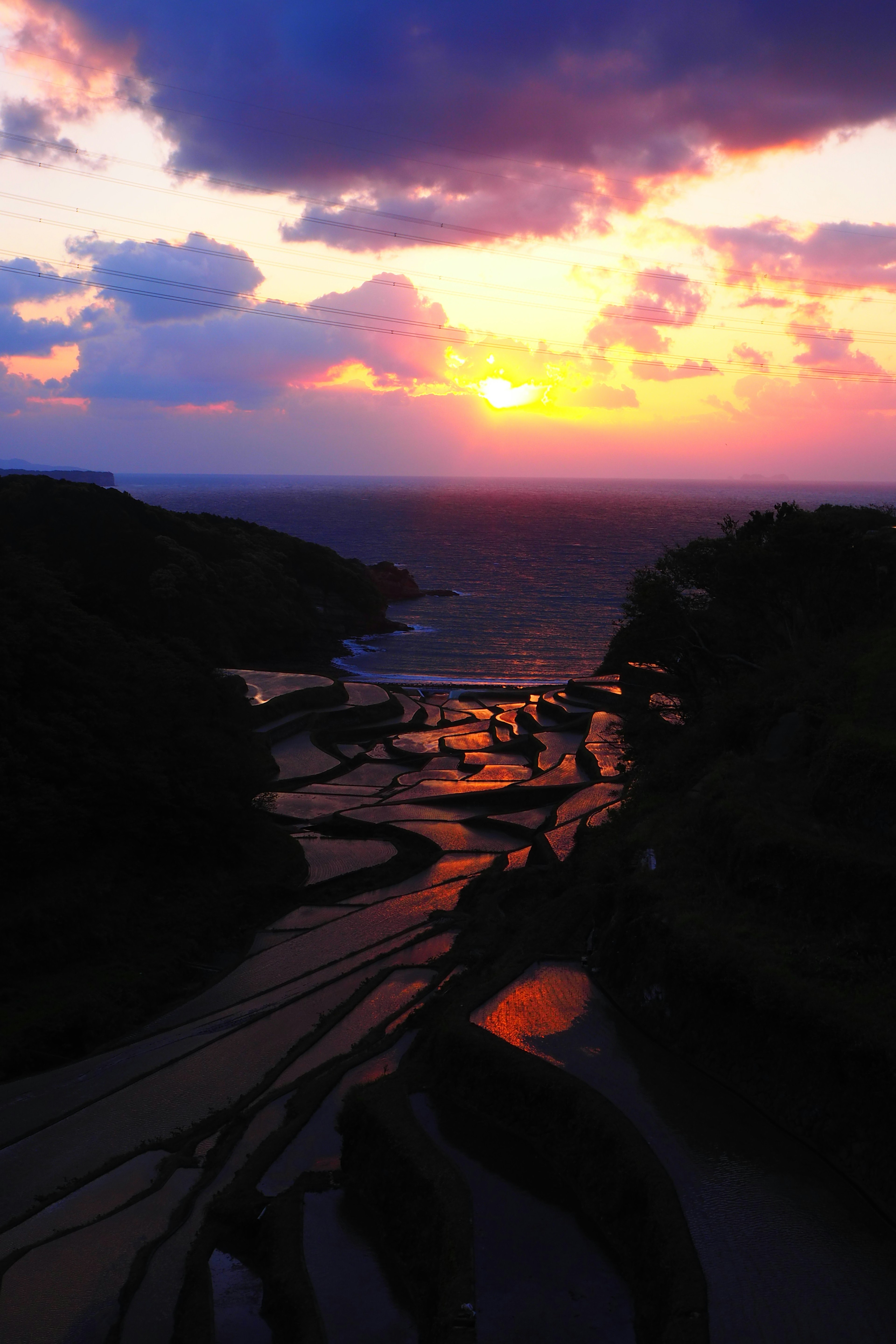 Stupendo paesaggio del mare e del tramonto con formazioni rocciose scure