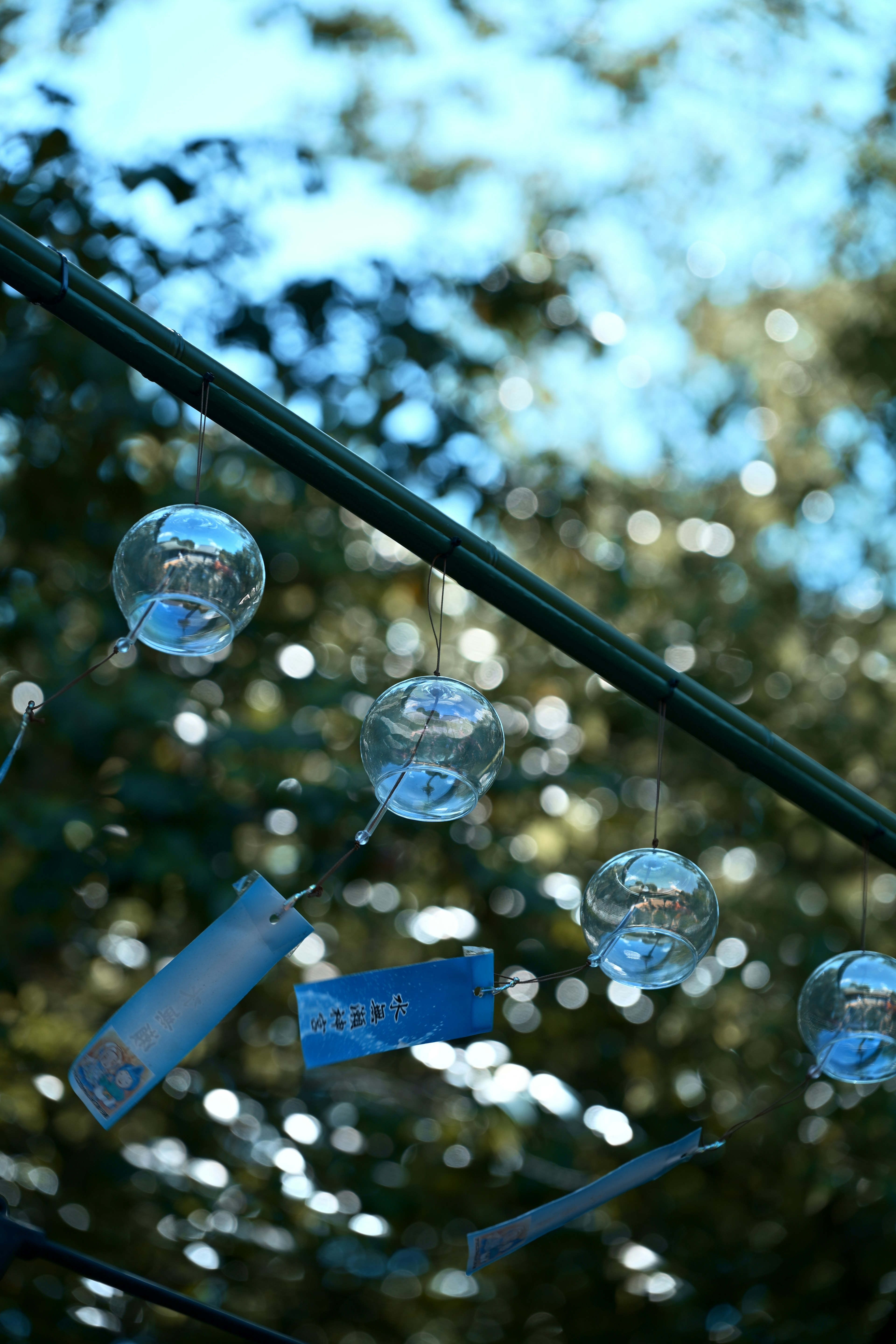 Boules en verre et objets bleus suspendus sous un ciel bleu