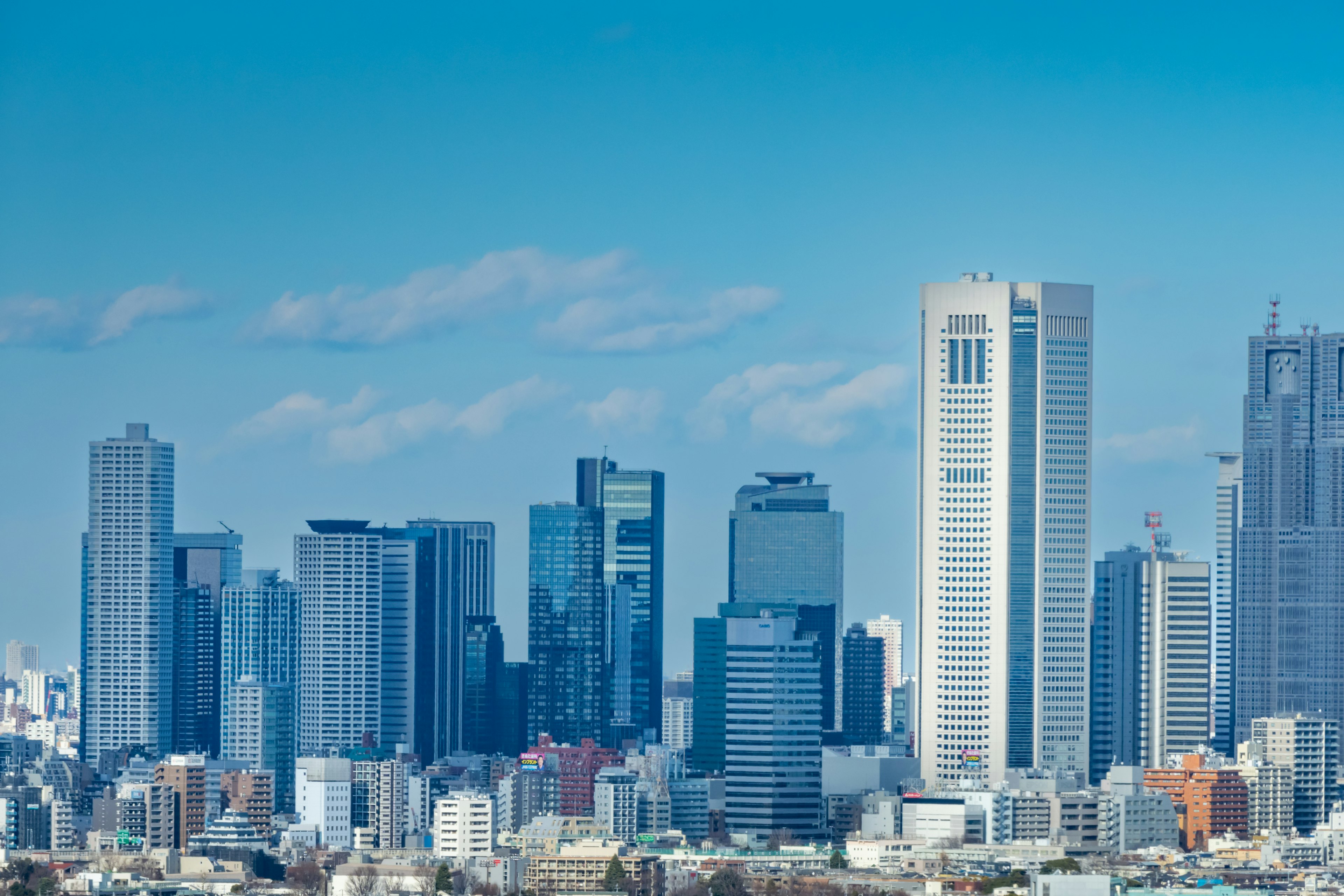 Garis langit Tokyo dengan gedung tinggi di bawah langit biru yang cerah