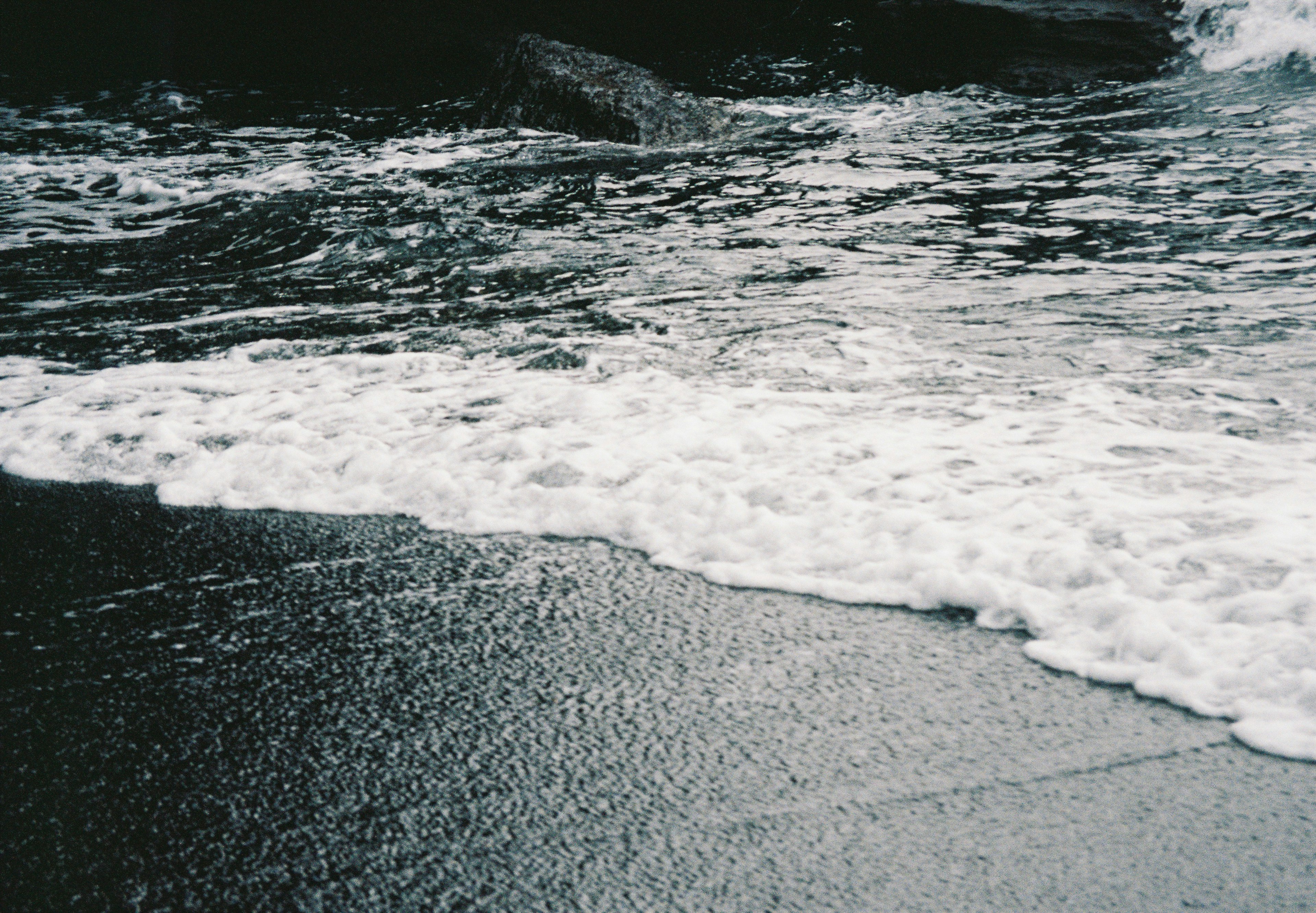 Onde che si infrangono su una spiaggia di sabbia nera