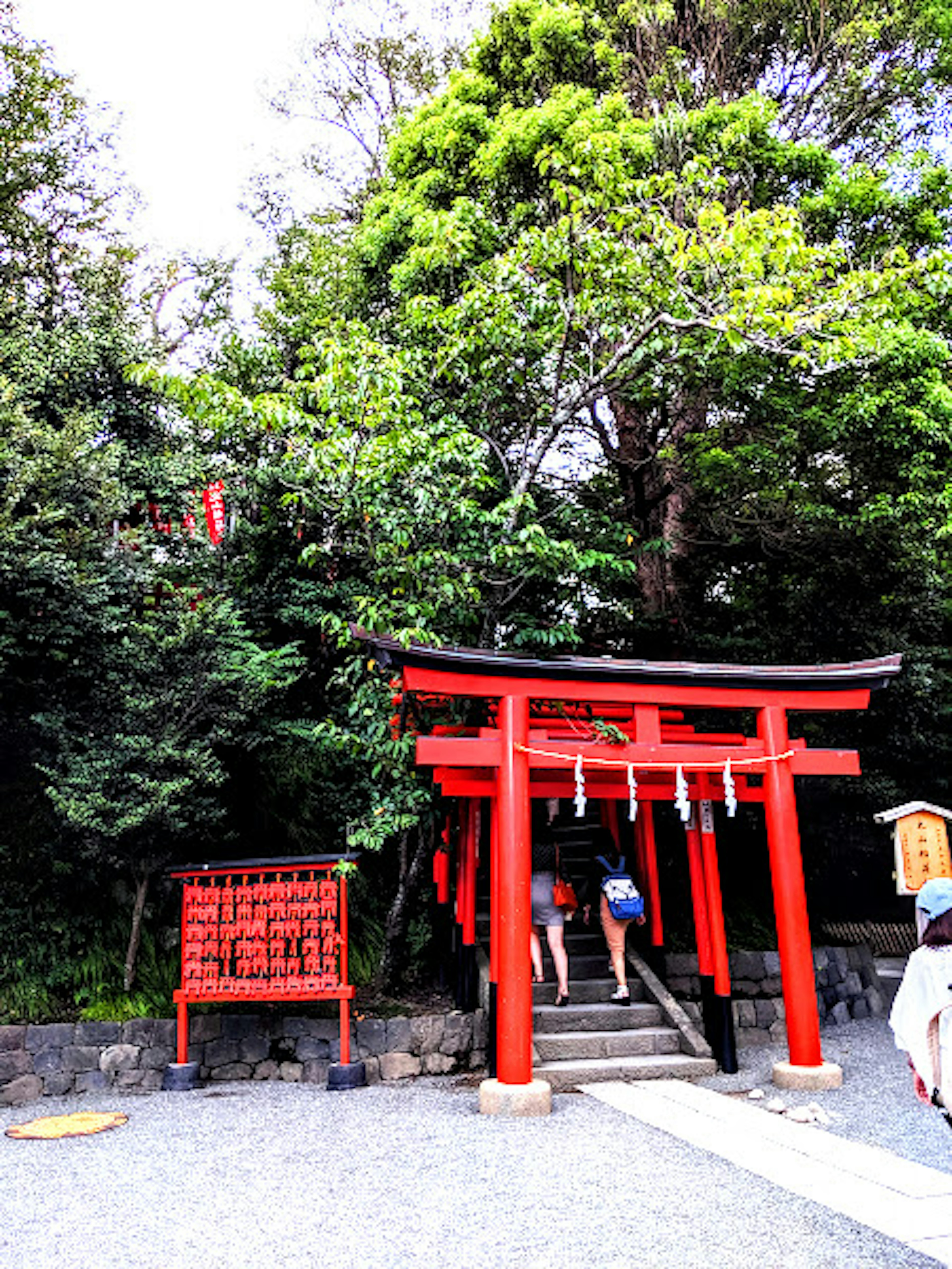 赤い鳥居の前に人々がいる神社の風景