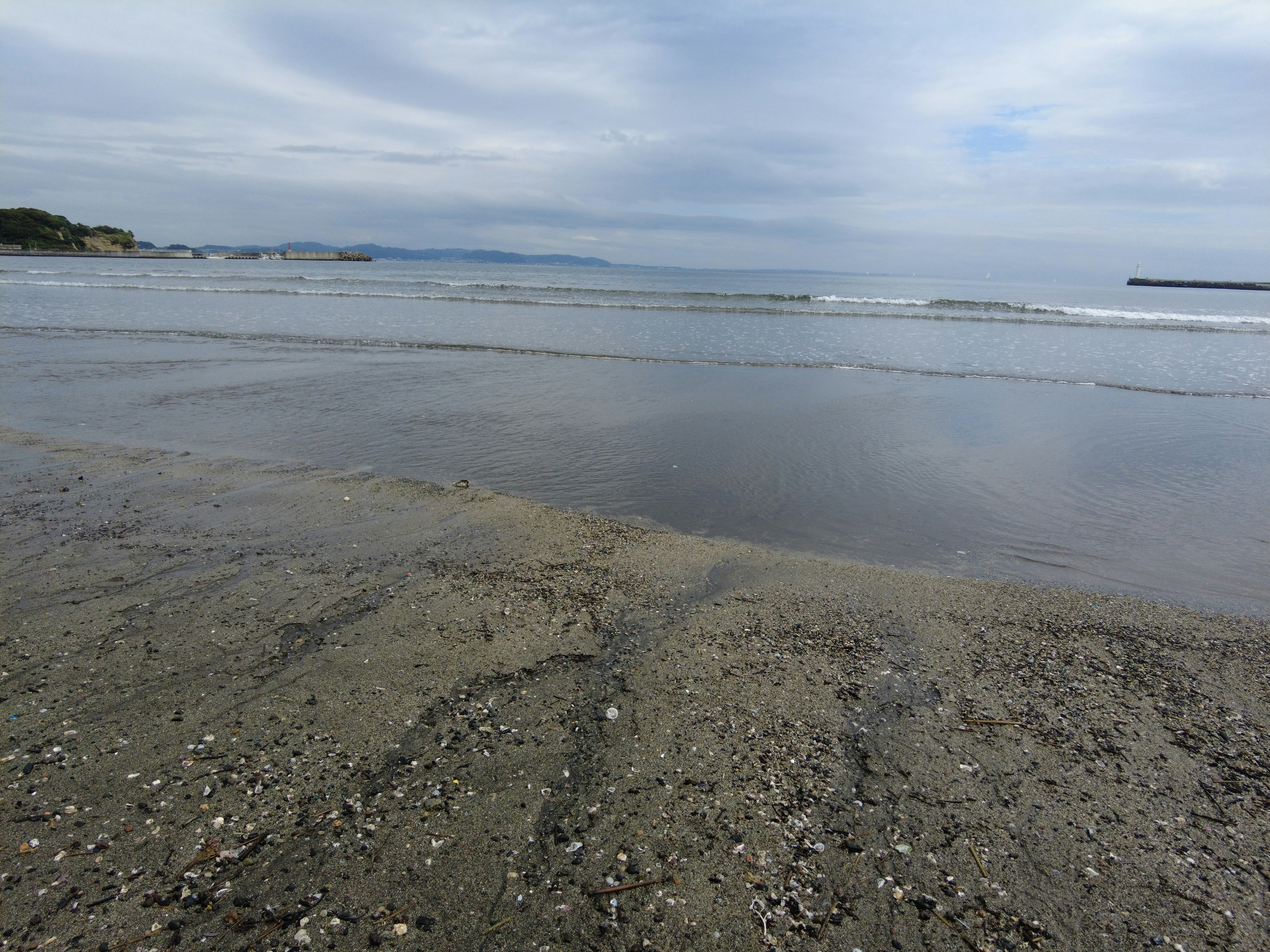 Pemandangan pantai dengan pasir dan ombak lembut