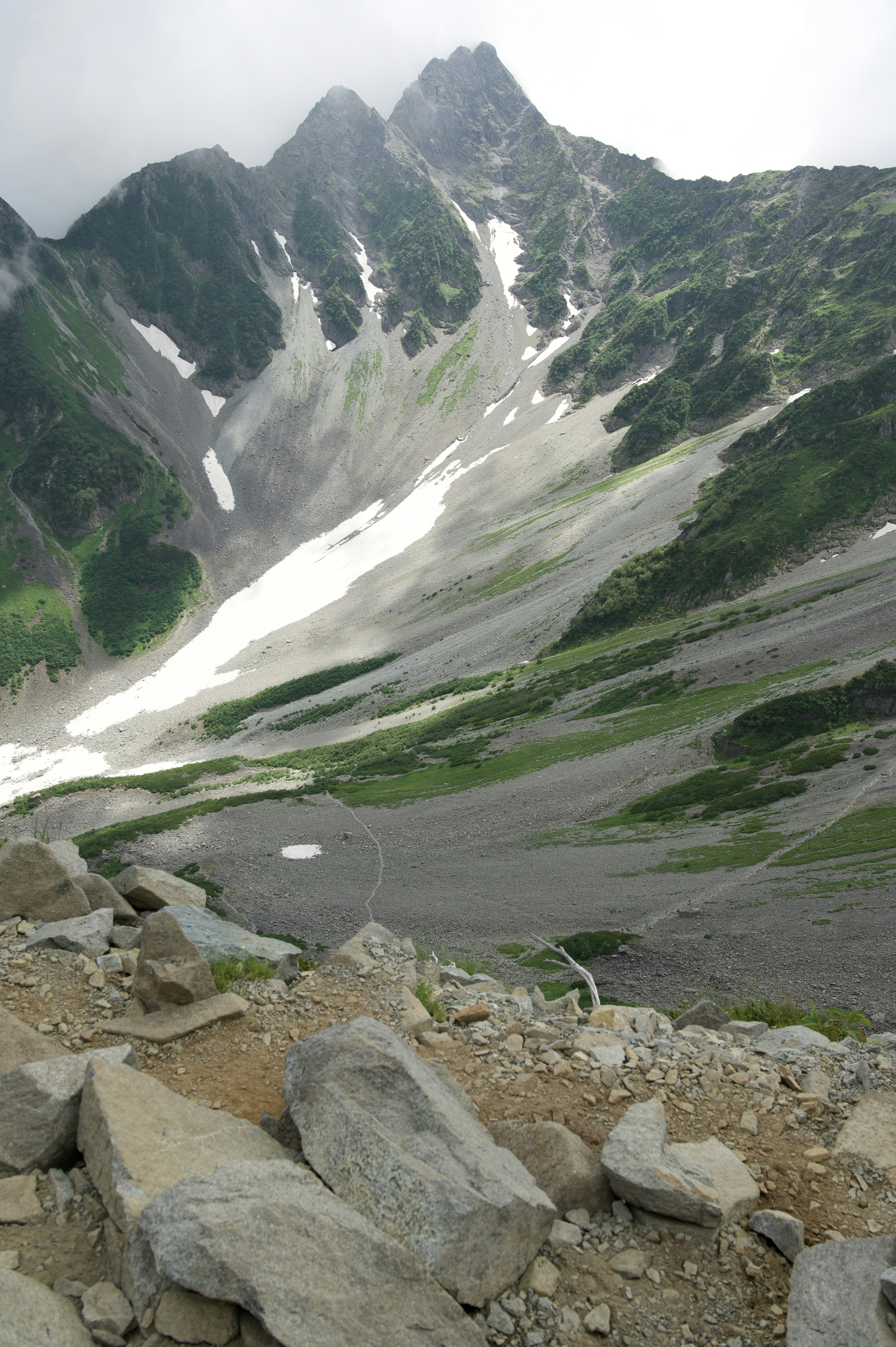 Paesaggio montano con ghiacciai verdi e bianchi terreno roccioso cielo nuvoloso