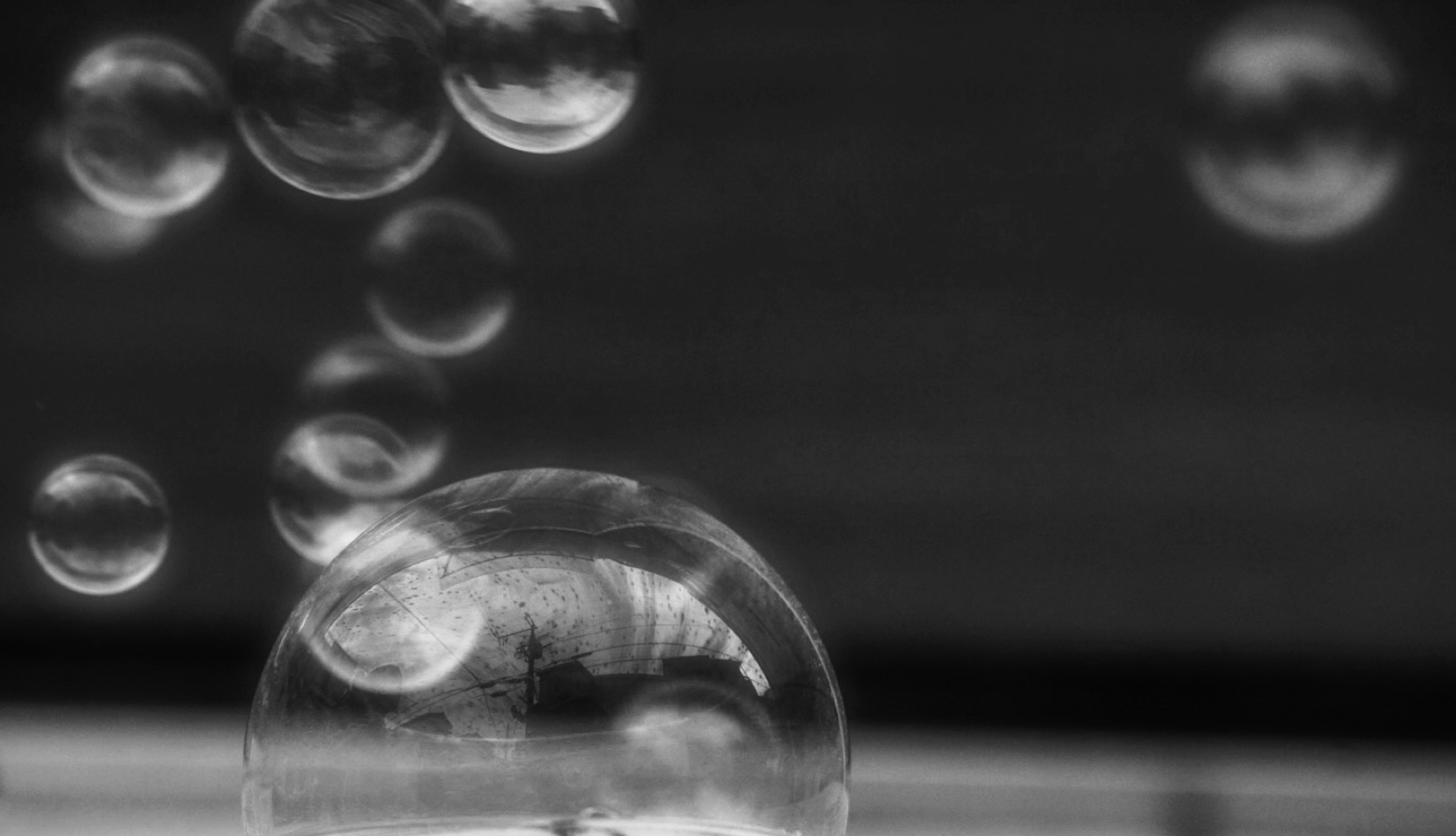 Primer plano de burbujas transparentes flotando sobre un fondo en blanco y negro