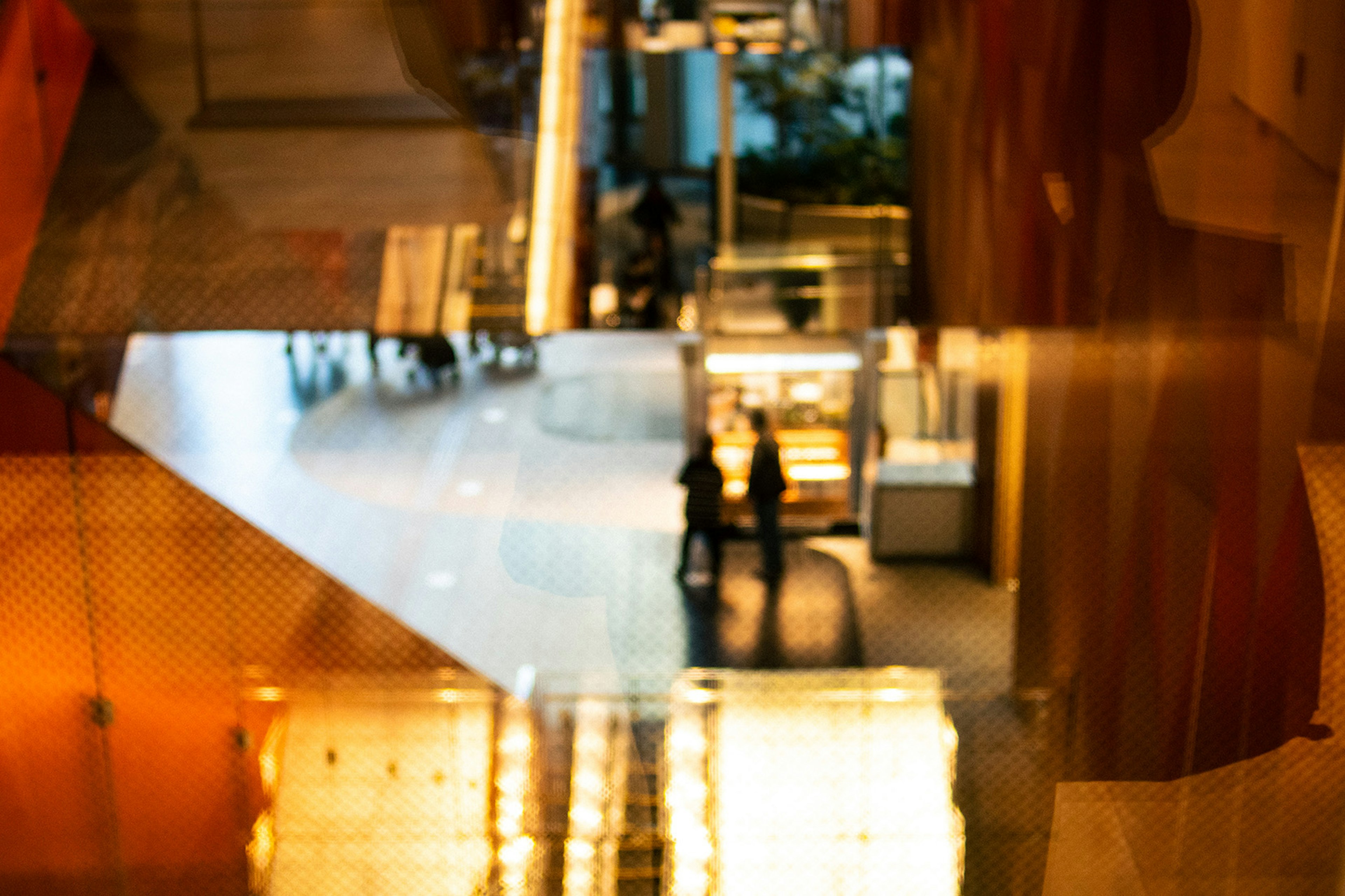 Two people in a modern building interior with reflections of light