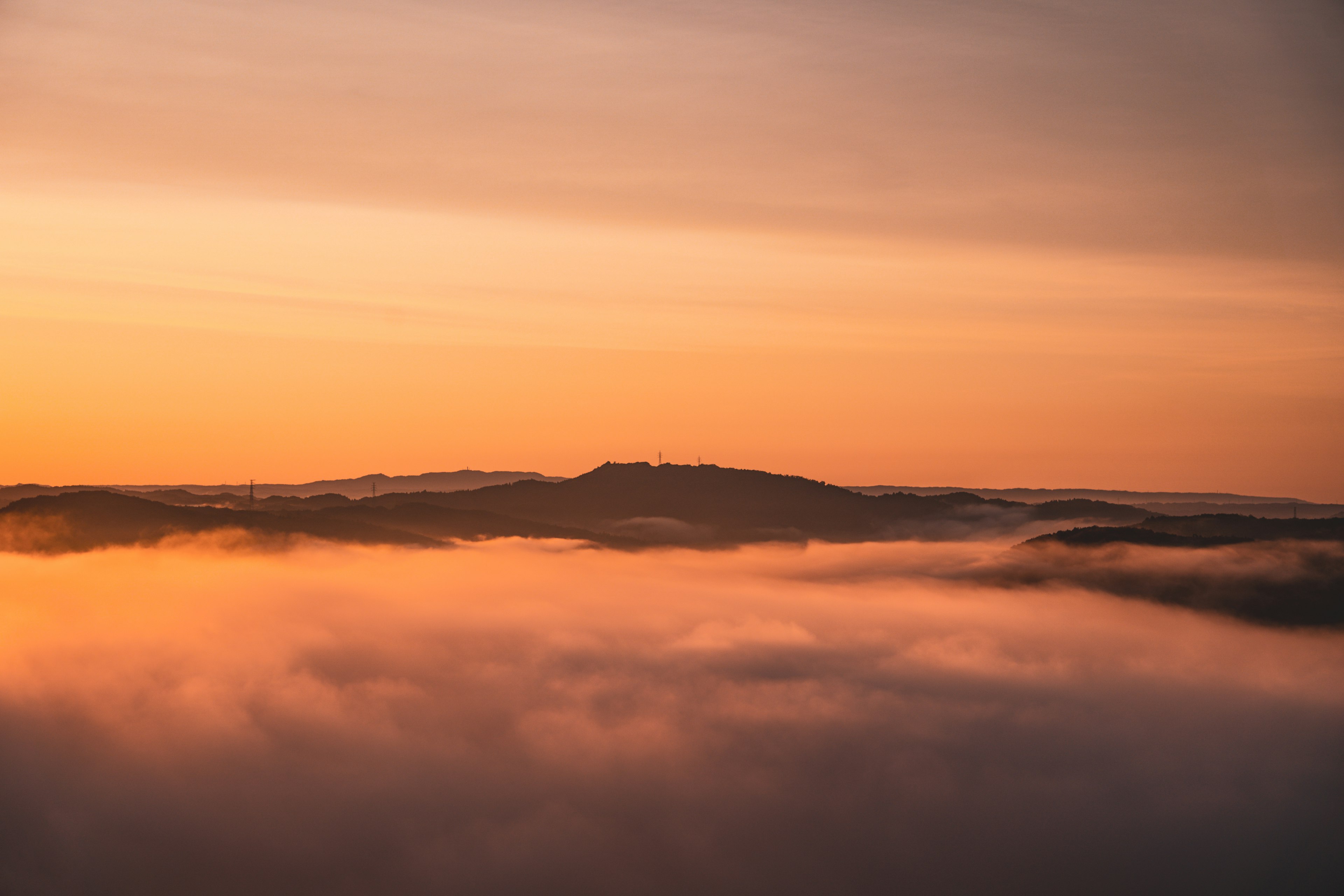 Sommet de montagne au-dessus d'une mer de brouillard au coucher du soleil